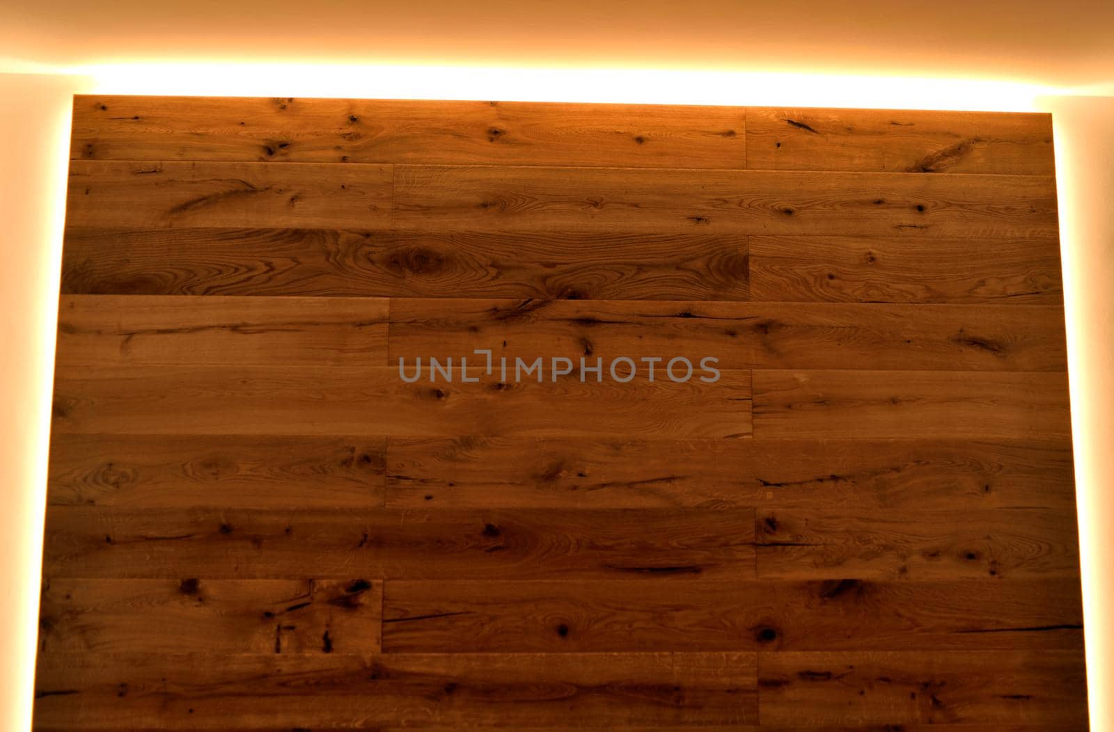 Closeup of a wall covered with parquet with its natural veins, delimited by LED strips. by silentstock639