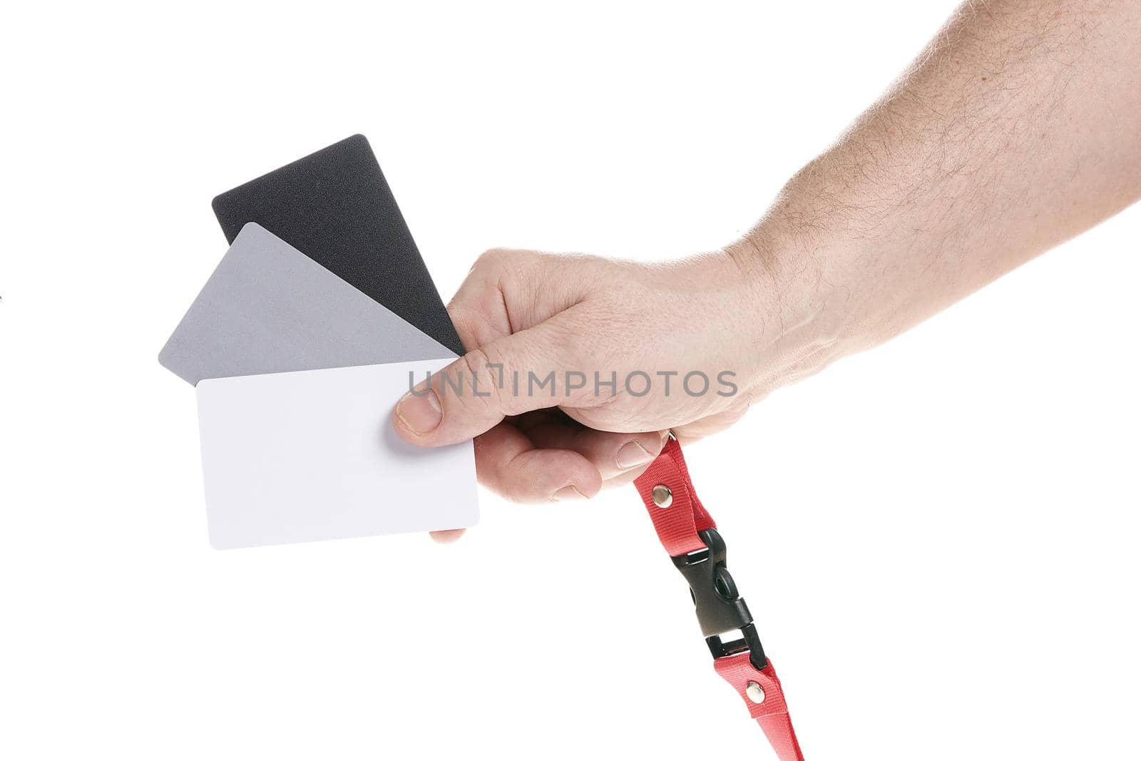 Hand holds a set of gray cards for adjusting the white balance on a white background, a template for designers