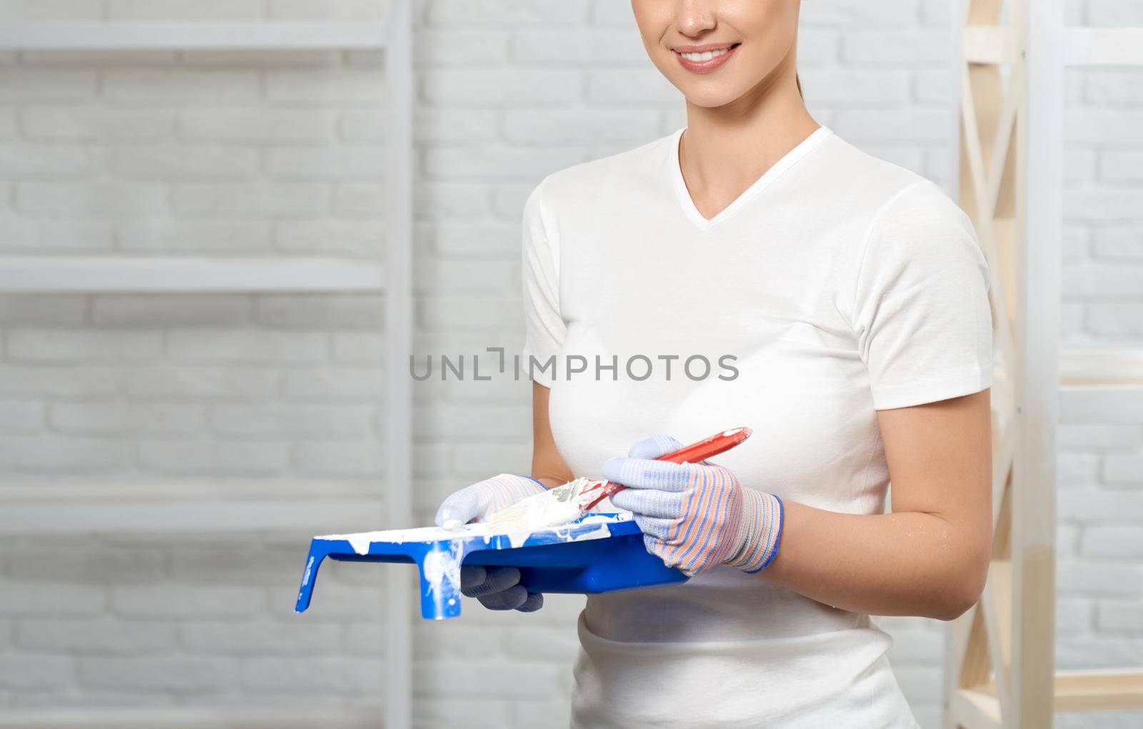 Smiling young woman holding paint. by SerhiiBobyk