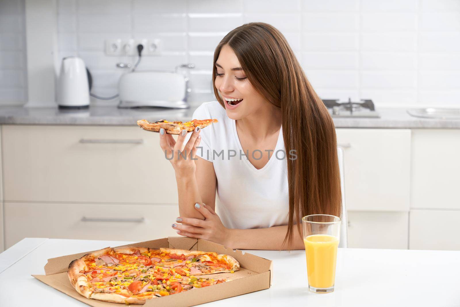 Beautiful brunette eating pizza at home. by SerhiiBobyk