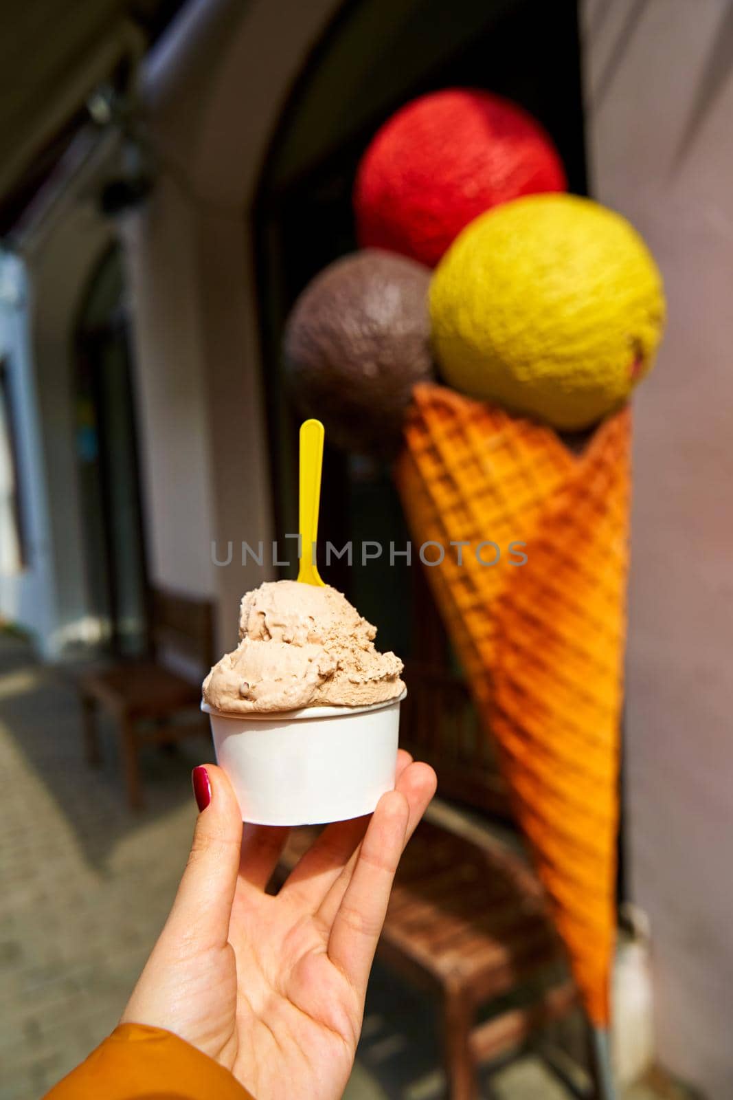 Ice cream in a paper cup. Sweets and weekend walks.