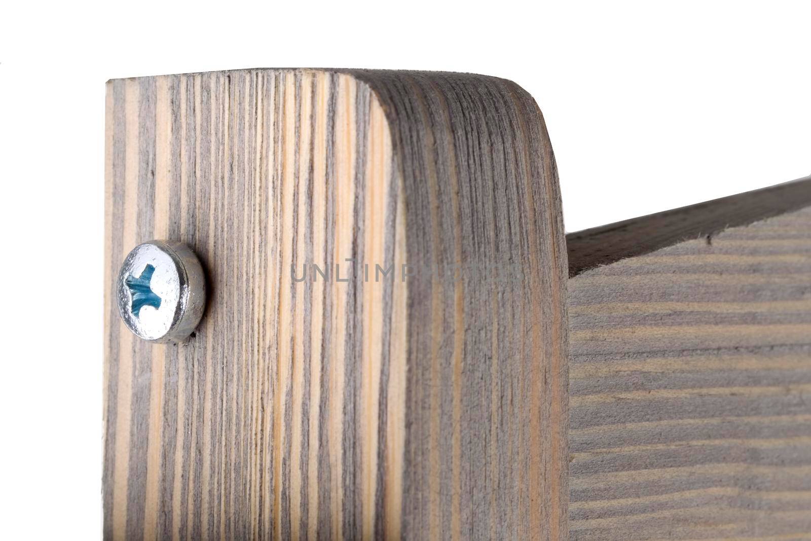 Fragment of a wooden product with a screw on a white background close-up