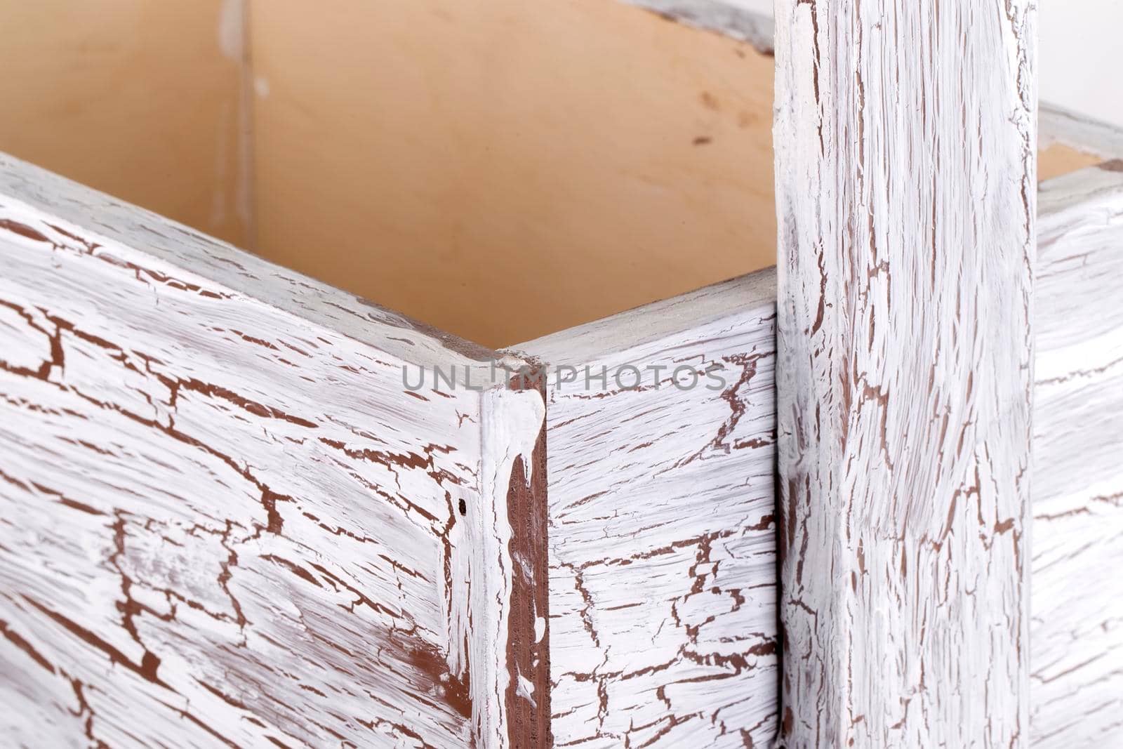 Detail of a wooden box with aged paint close-up on a white background