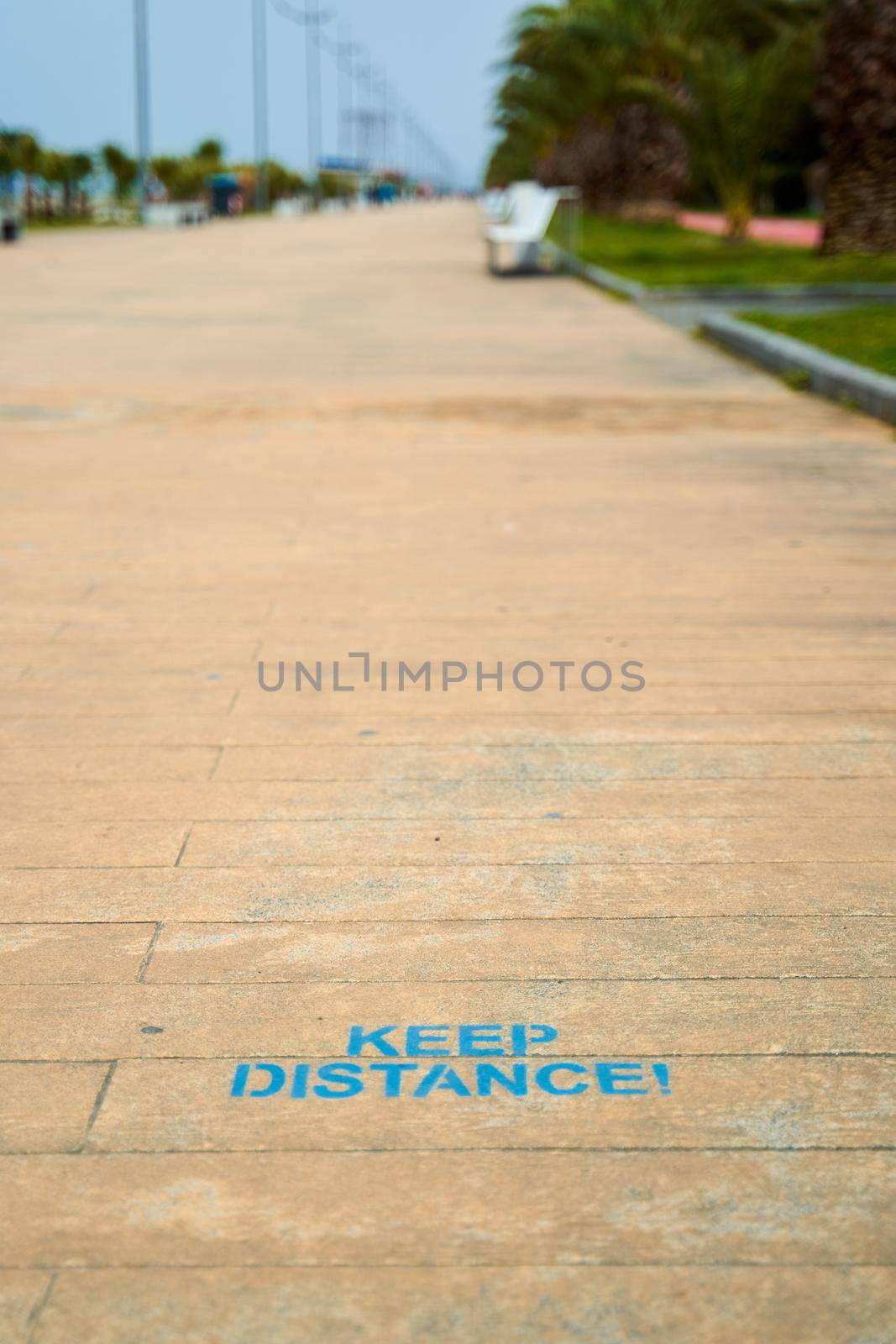 the inscription on the floor is a reminder of keeping the distance. Walking path on the embankment.