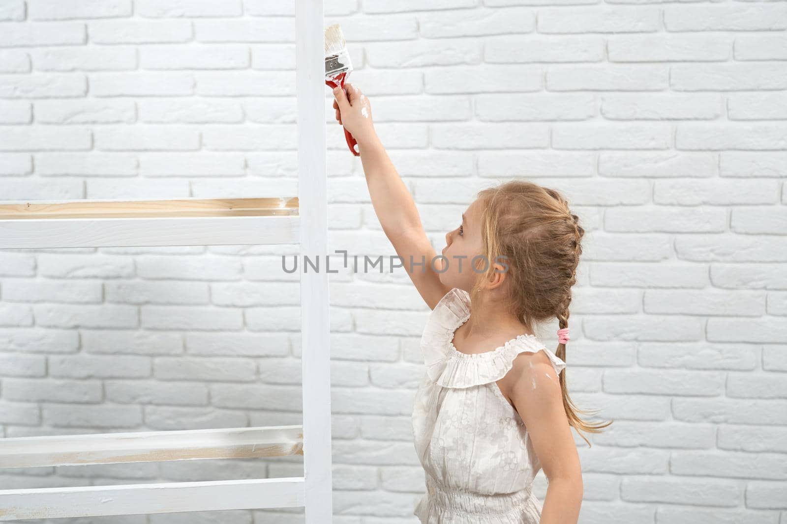 Child holding brush and painting rack in white color. by SerhiiBobyk