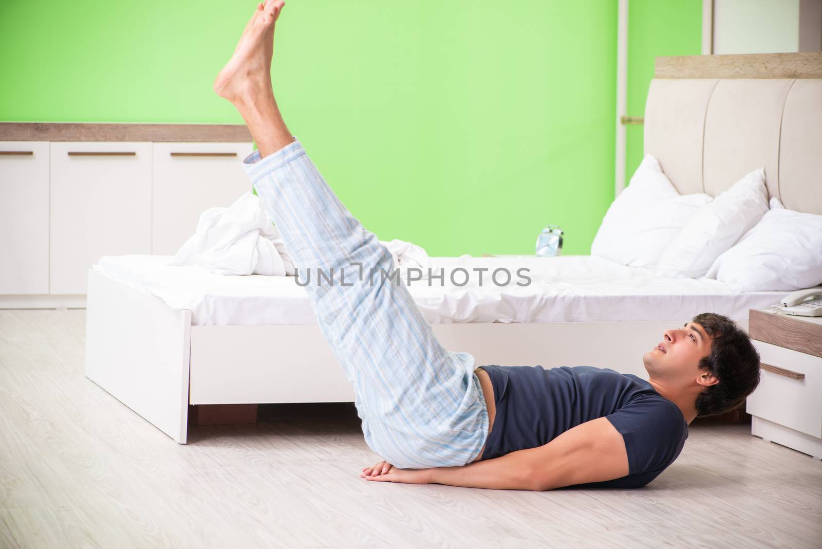 Young man in pajamas doing morning exercises  by Elnur