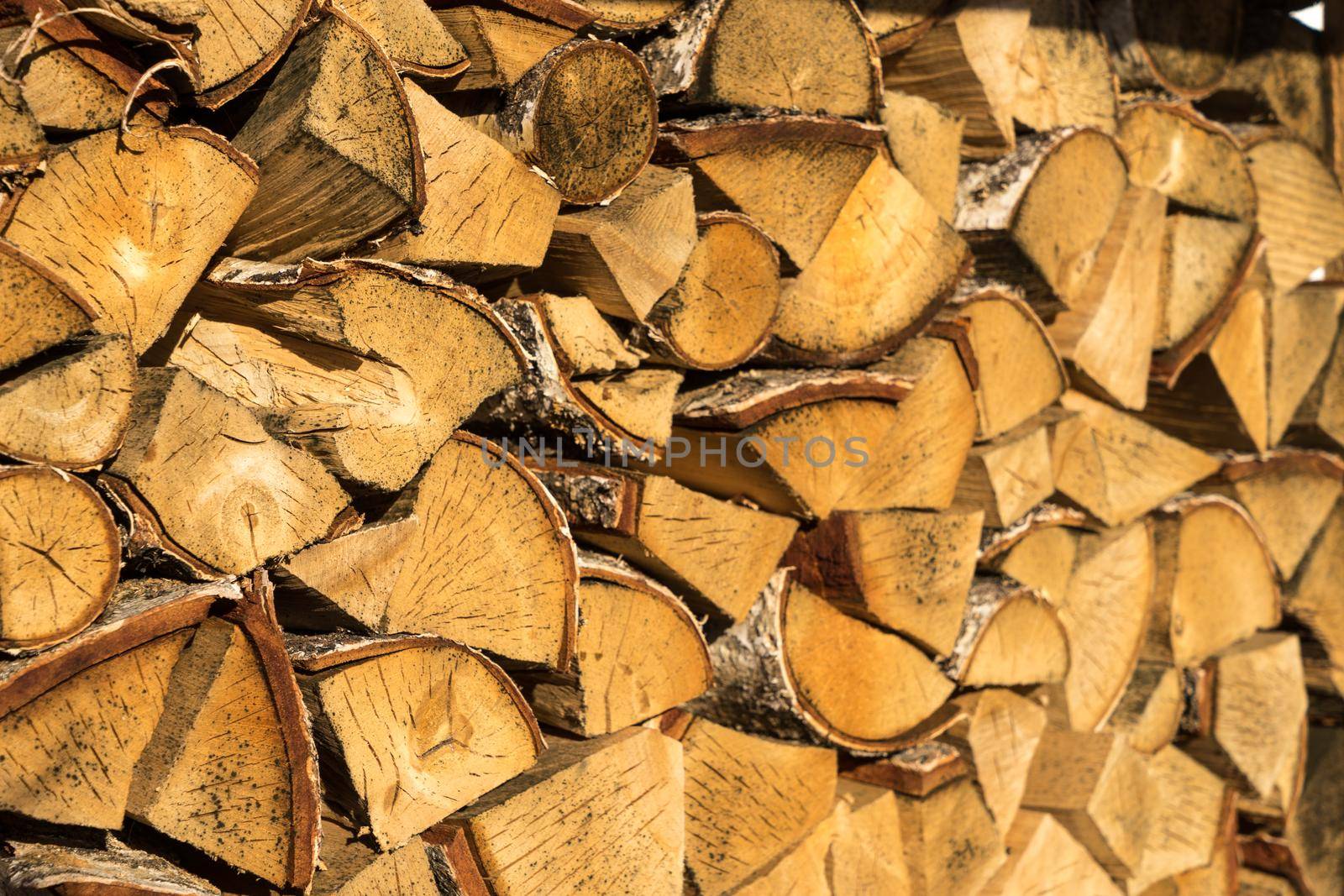 Pile of neatly stacked chopped timber logs for the fireplace