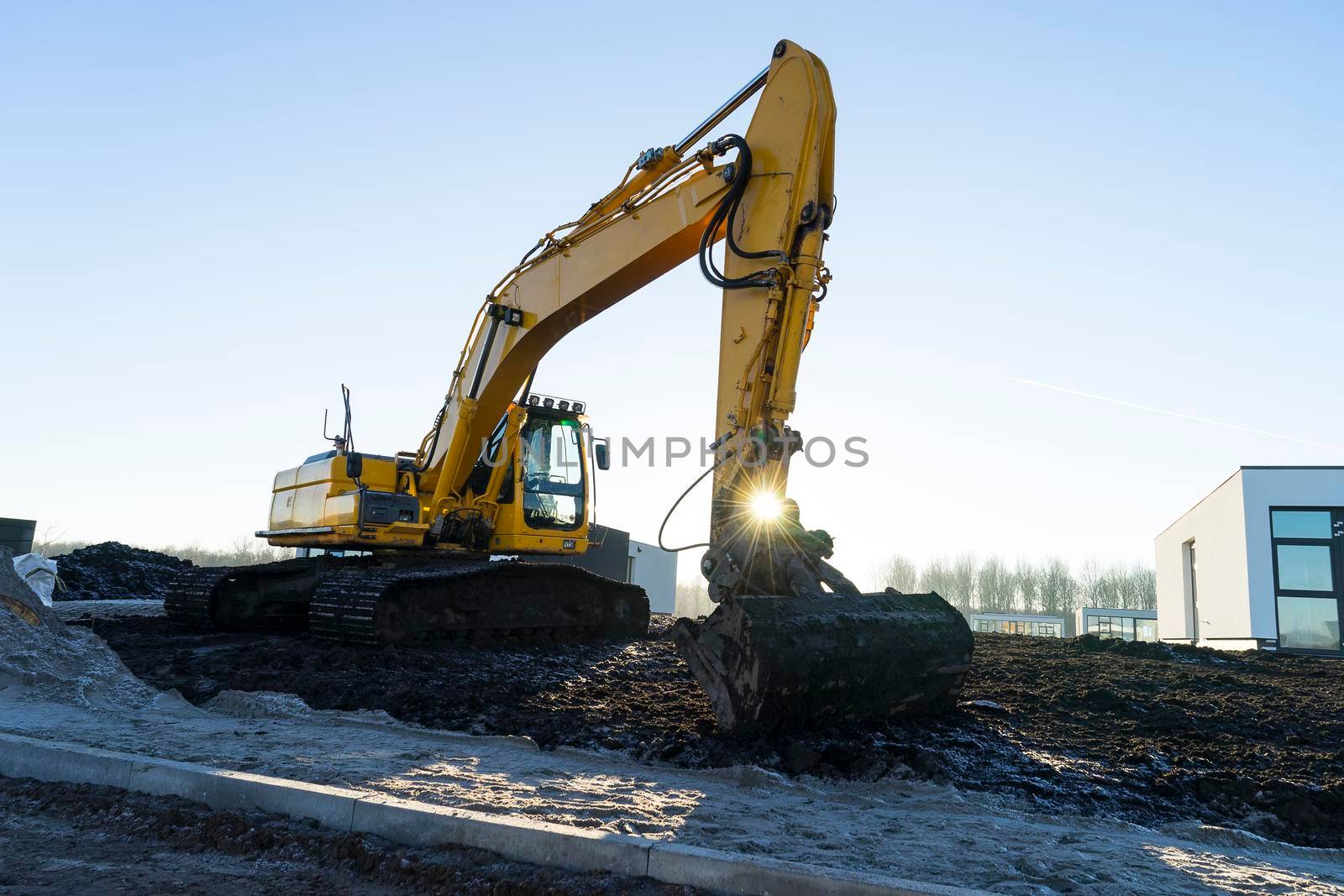 Power showel excavator at a construction site in the evening at sunset by LeoniekvanderVliet