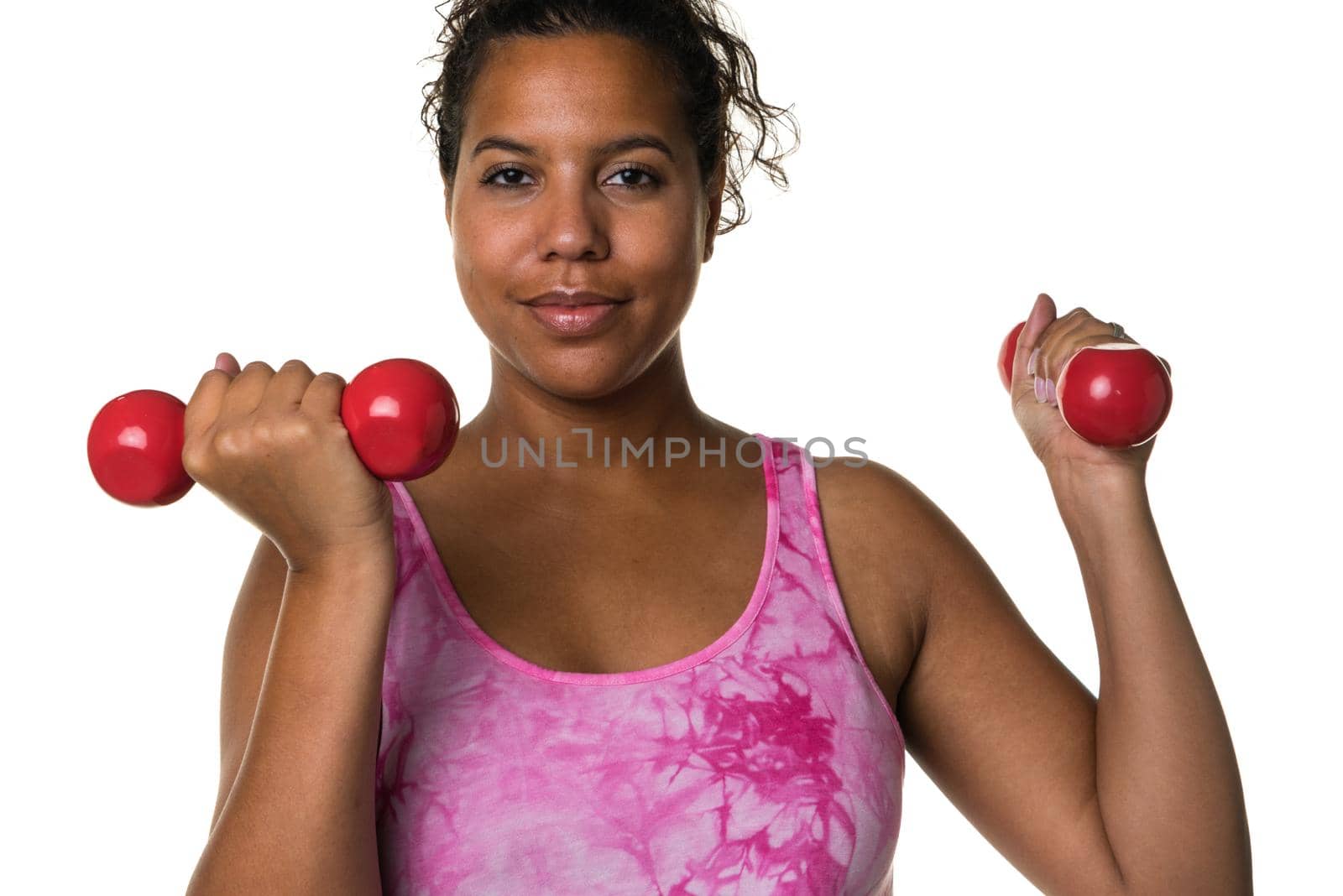 Mixed raced young woman  in pink shirt exercising with red 2 kg weights dumbbells isolated in white by LeoniekvanderVliet