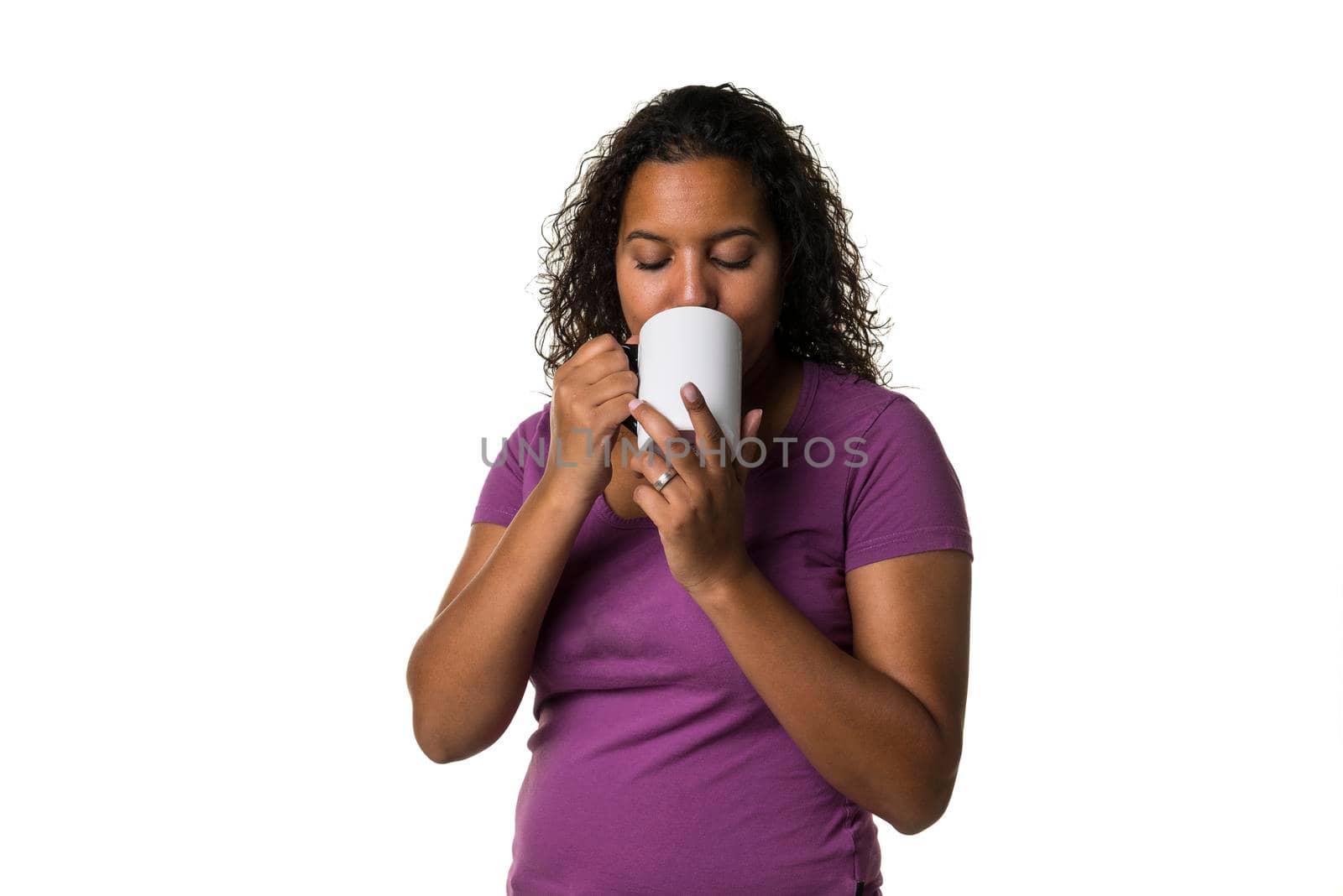 Young mixed race woman in purple shirt drinking a hot liquid from a black and white cup isolated with a white background by LeoniekvanderVliet