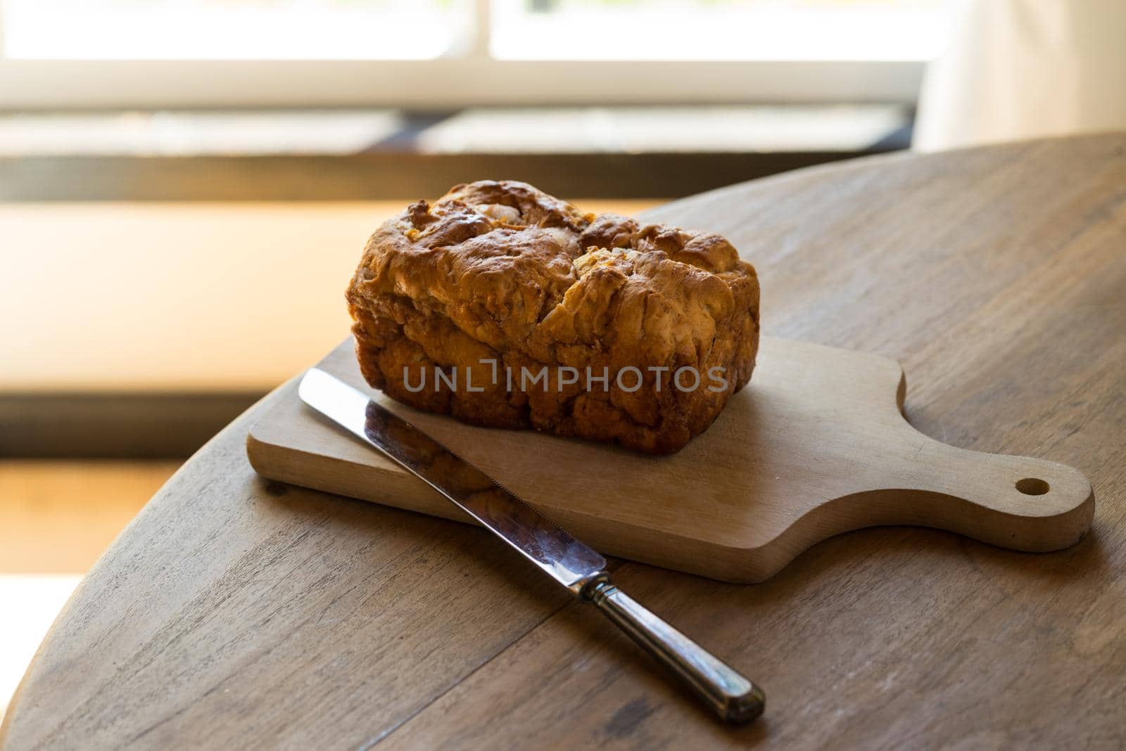 Traditional Dutch Frisian sugarbread or sugarloaf on a wooden chopping board on a table in front of a window