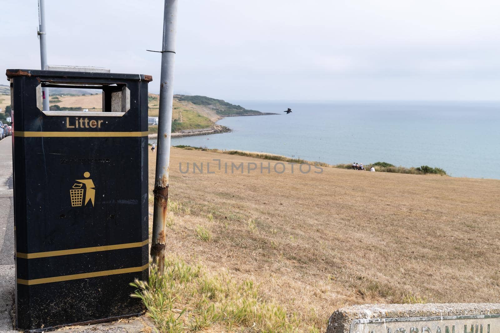 Black and yellow litter bin or garbage can at a coastal area in Great Brittain England south coast by LeoniekvanderVliet