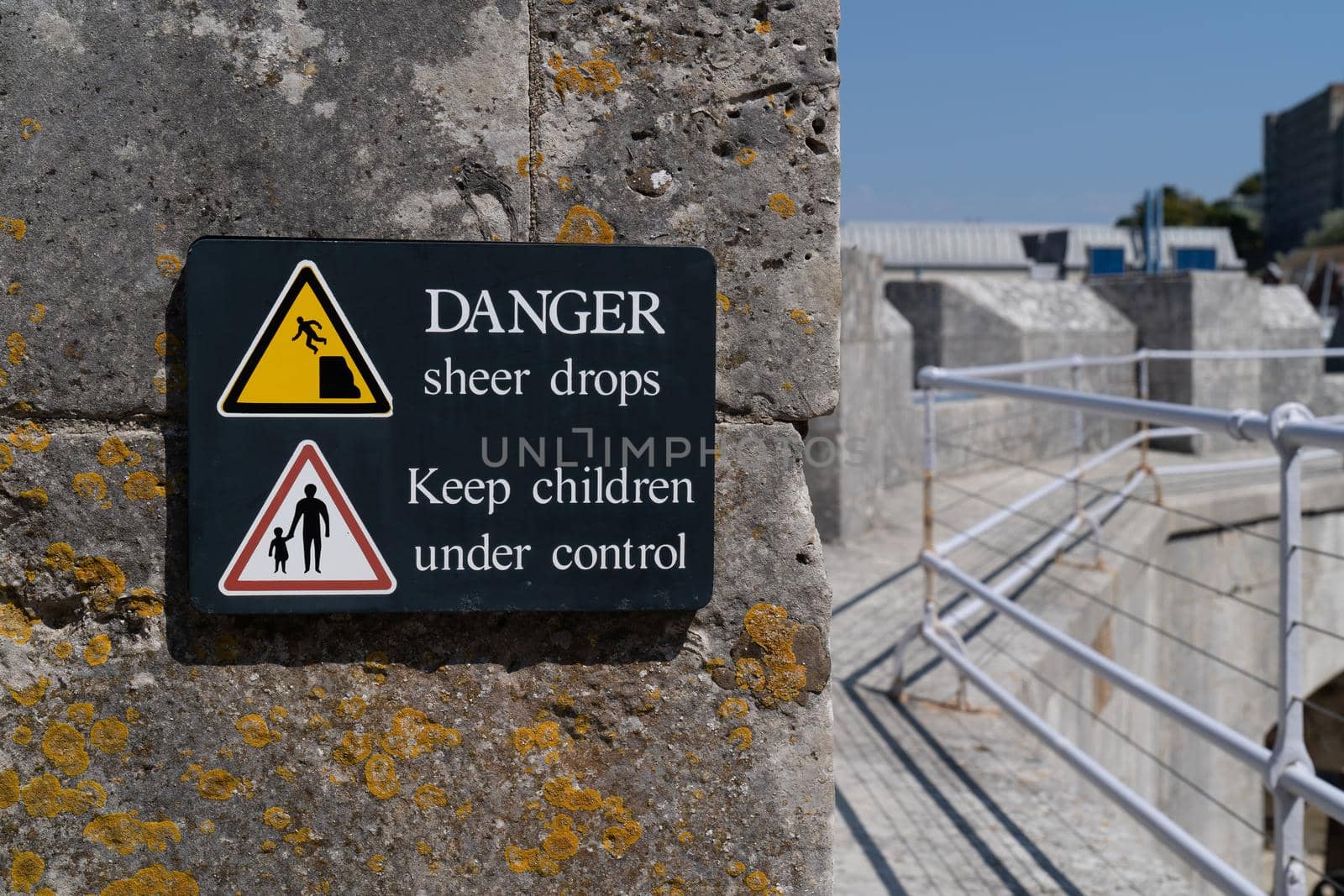 Danger sudden drop sign yellow warning triangle with symbol of man falling from a cliff edge and keep children under control sign on rampage