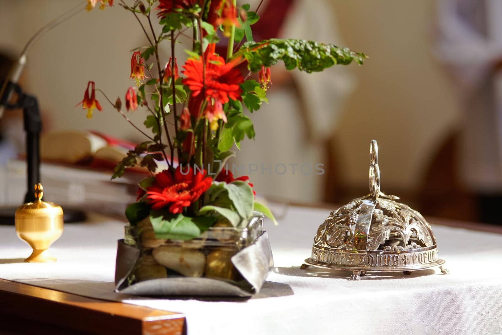 An altar bell and flowers at an altar prepared for mass by LeoniekvanderVliet