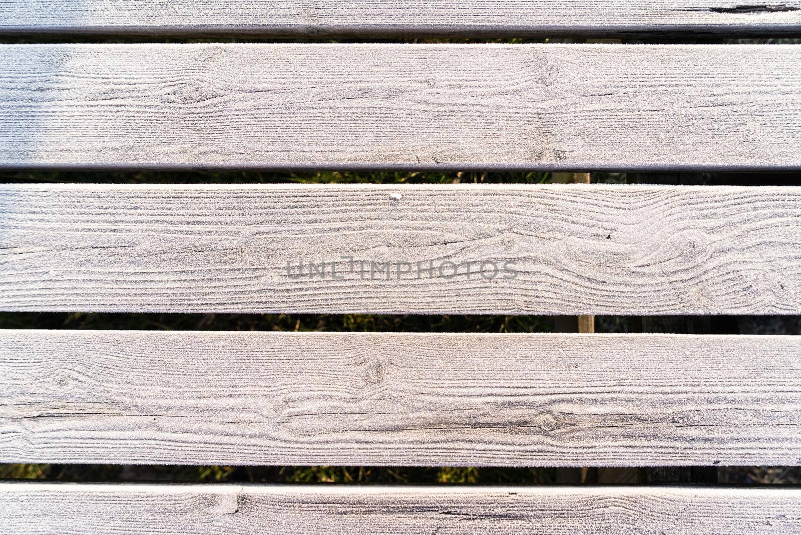 Wooden planks with a frozen layer of icecrystals full frame background