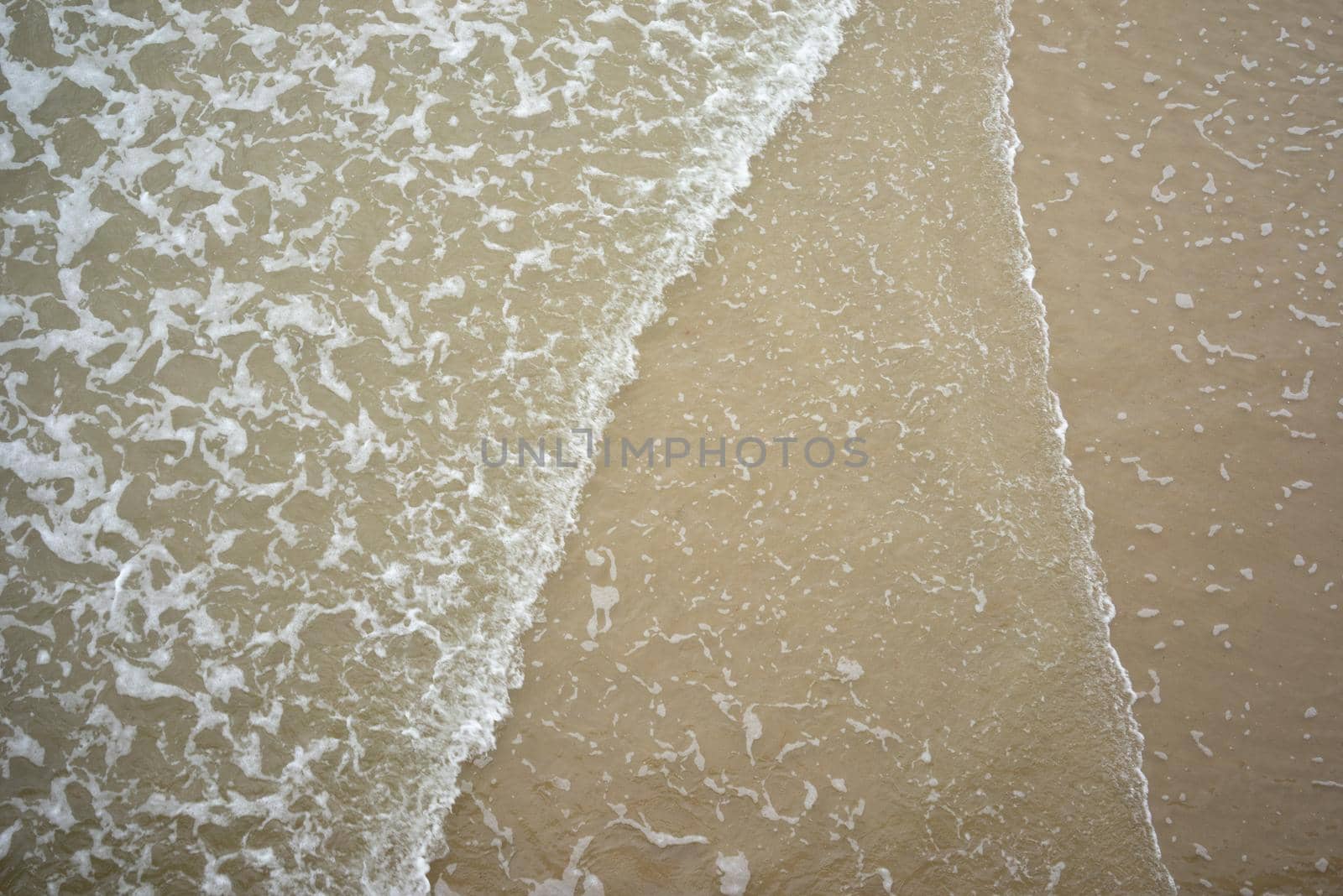 Sandy beach and sea wave seen from above, background. Forthcoming vacation concept. Copyspace. Top view by LeoniekvanderVliet