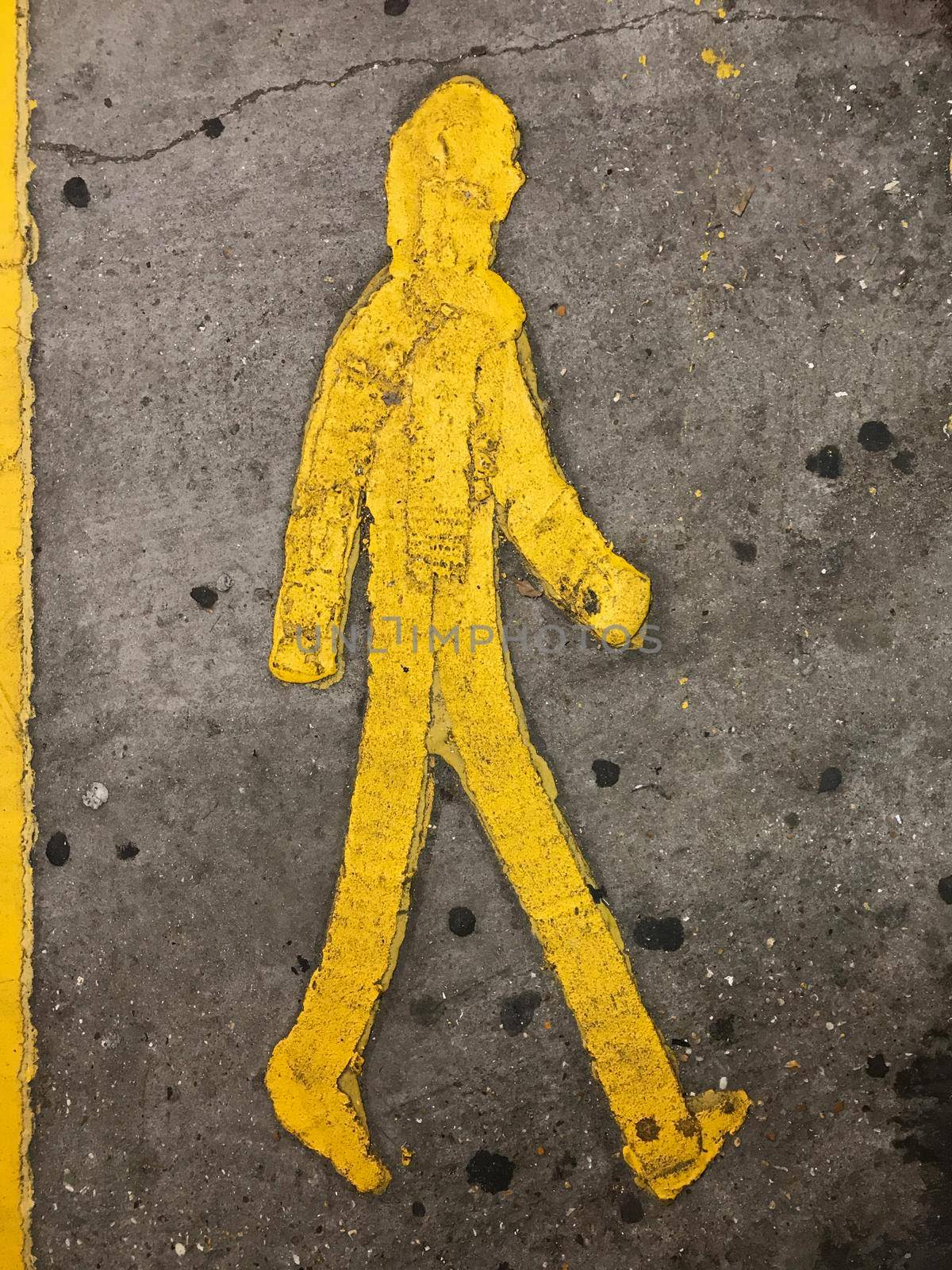 Sign of a yellow person walking on the floor in a parkinglot by LeoniekvanderVliet