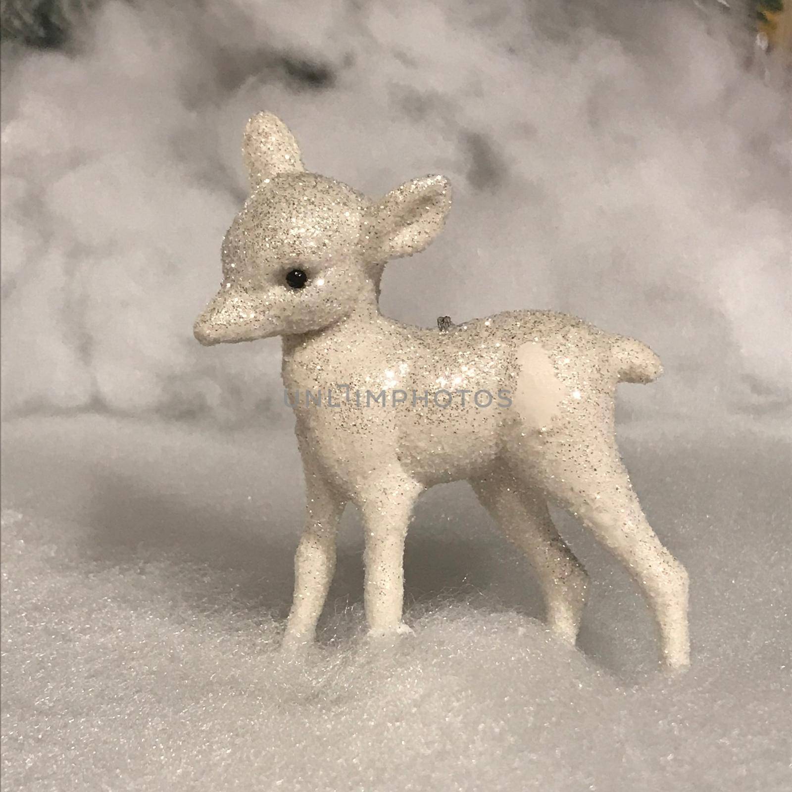 a Christmas scene with glitter lamb statue and fake snow