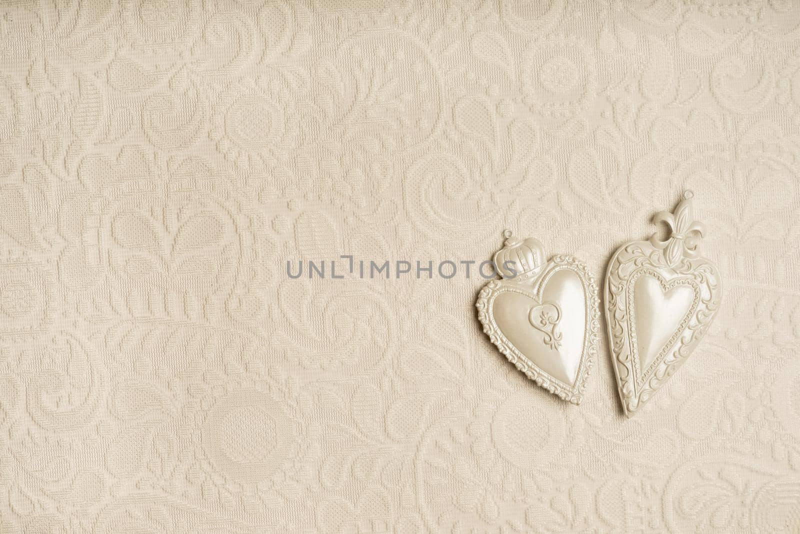 a Full frame background of two white hearts on a seamless detailed lace pattern on white background with copy space