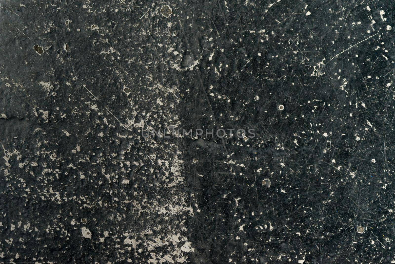 an empty background of black concrete that is worn down or weathered showing texture with copy space or space for tekst by LeoniekvanderVliet