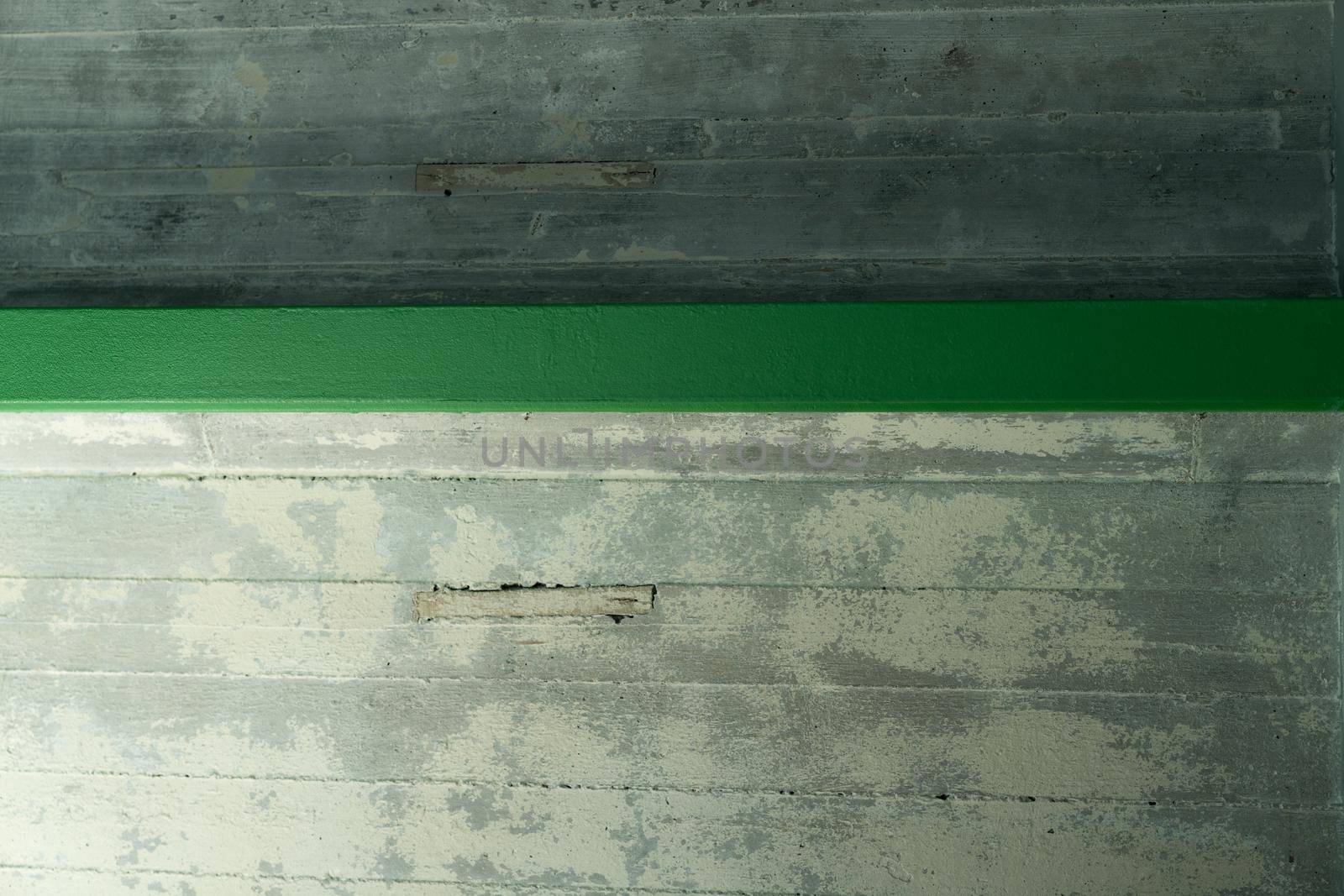 An abstract ceiling of concrete made of plates and green beams