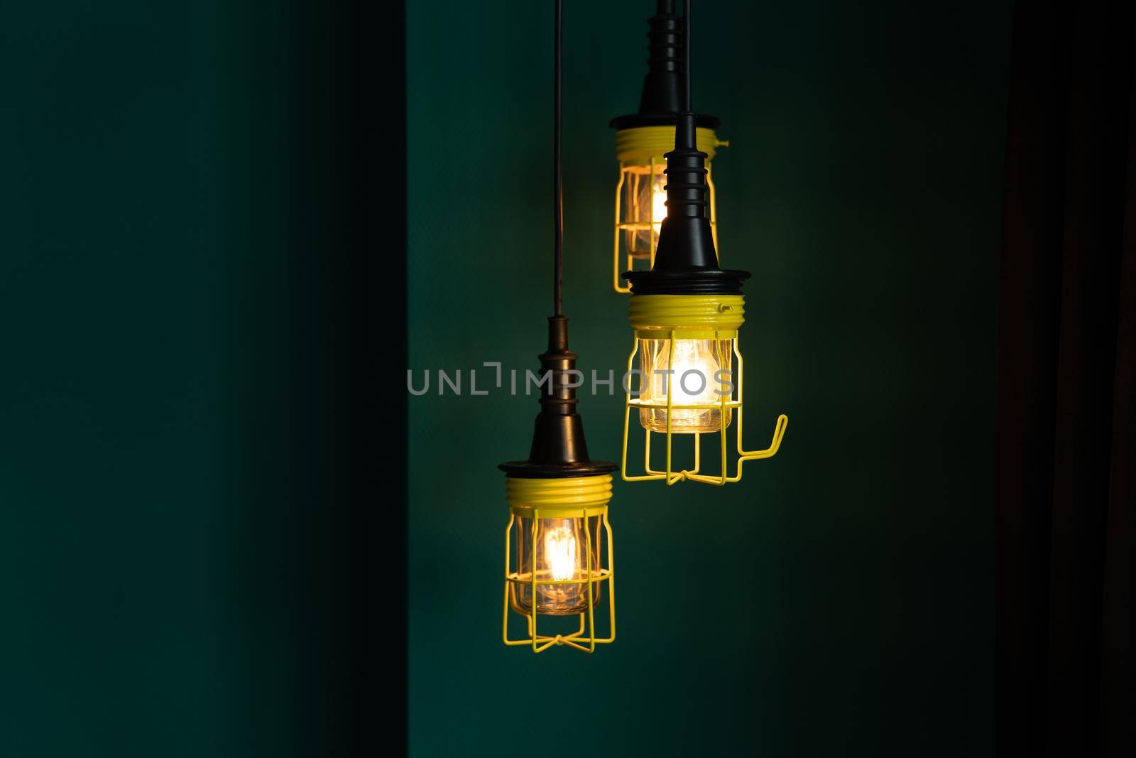 Interior with three yellow work or inspection lamps against a green wall by LeoniekvanderVliet