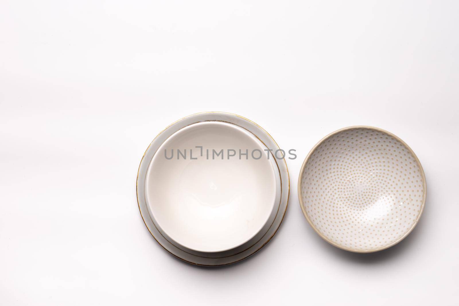 Three empty dishes or cups of blanc earthenware isolated on a white background seen from above or top view