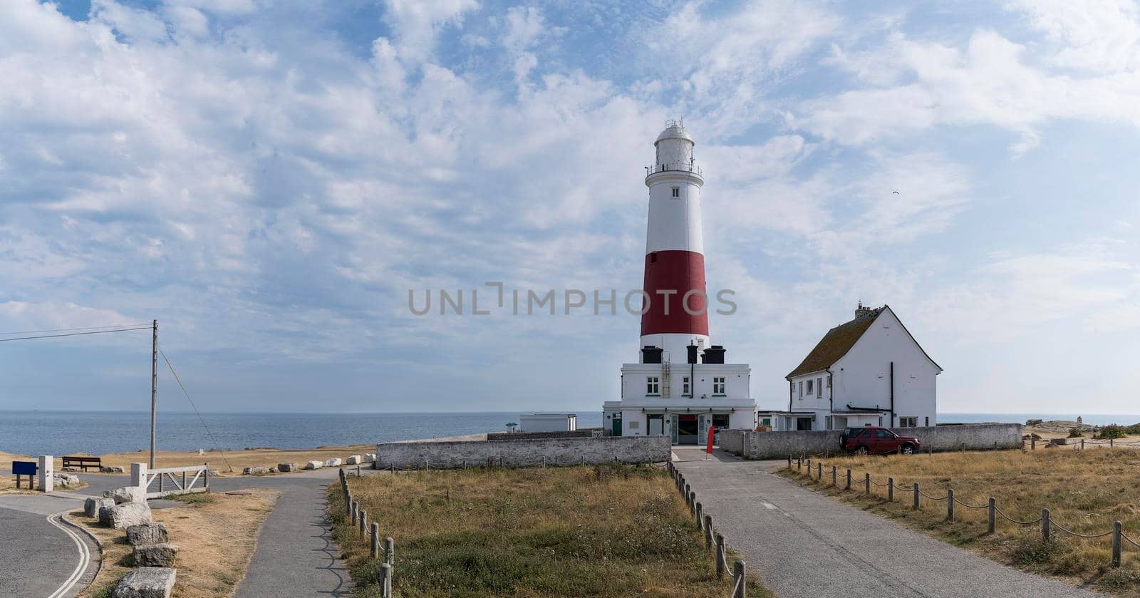 Panoramic view of the Isle of Portland bill lighthouse near Weymouth Dorset coast England UK with a cloudy sky and the ocean in the summer by LeoniekvanderVliet