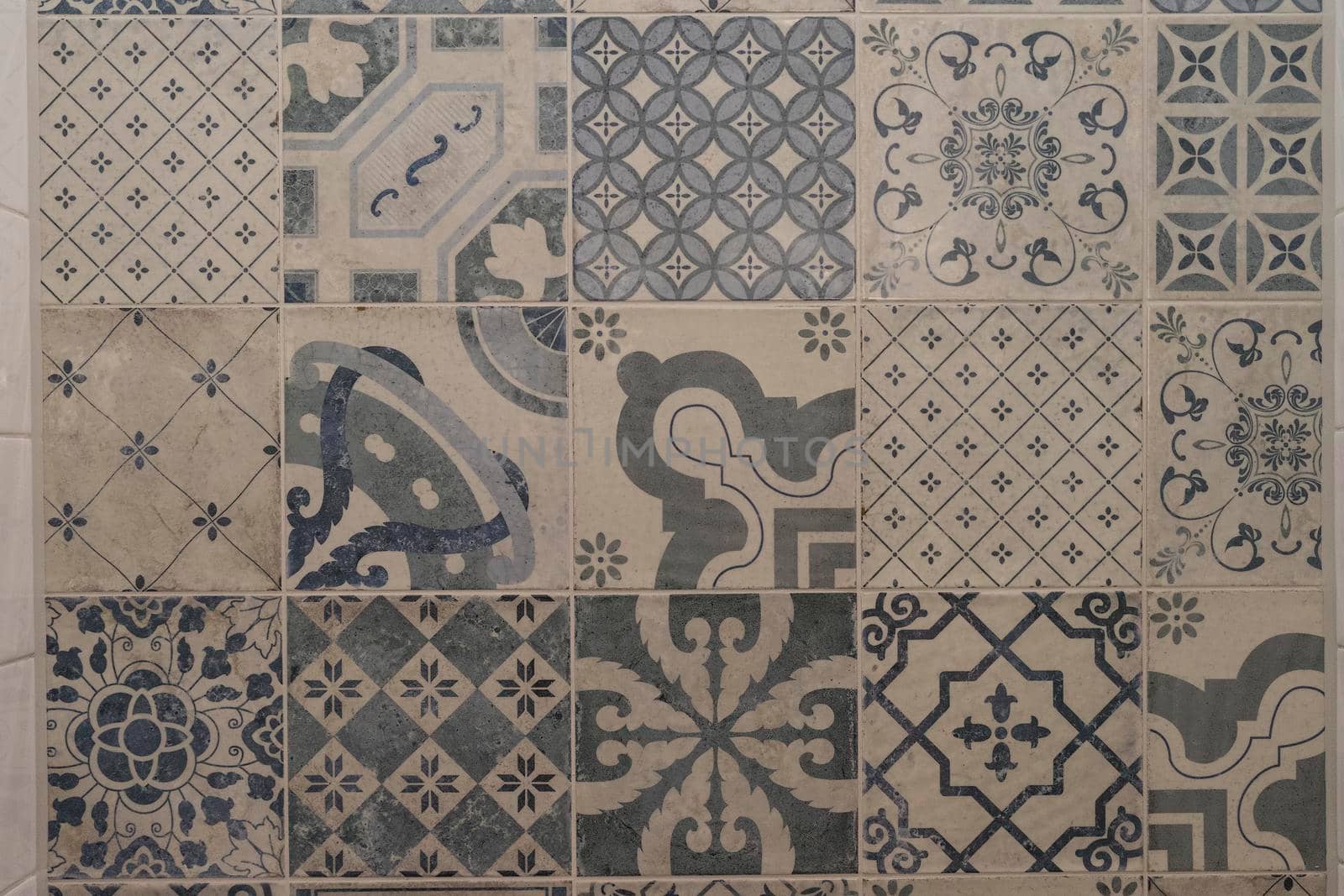 Decorative blue and cream tiles with different patterns on a wall by LeoniekvanderVliet