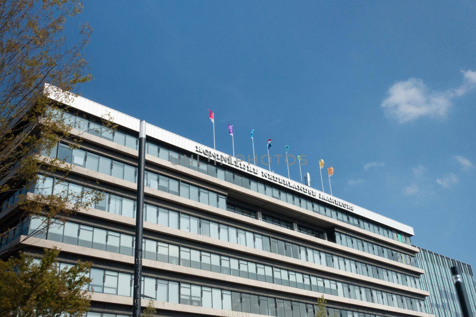 UTRECHT / NETHERLANDS - APRIL 15, 2019: Facade with flags and blue sky Dutch conference centre Jaarbeurs by LeoniekvanderVliet