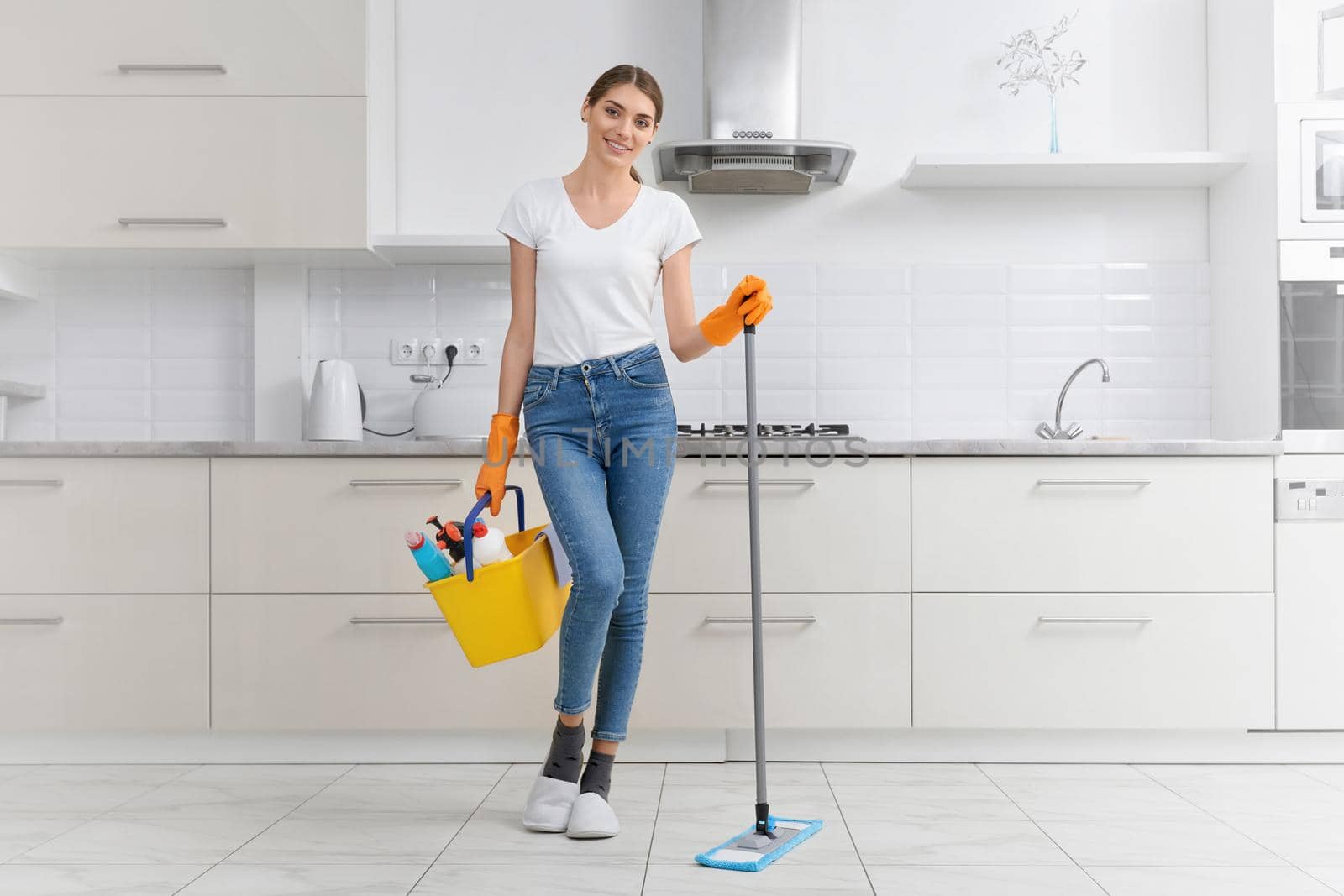 Smiling woman preparing for cleaning in kitchen. by SerhiiBobyk