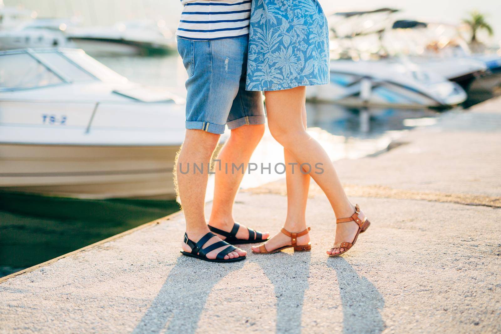 Newlyweds on the quay. Legs close-up. Wedding in Montenegro.