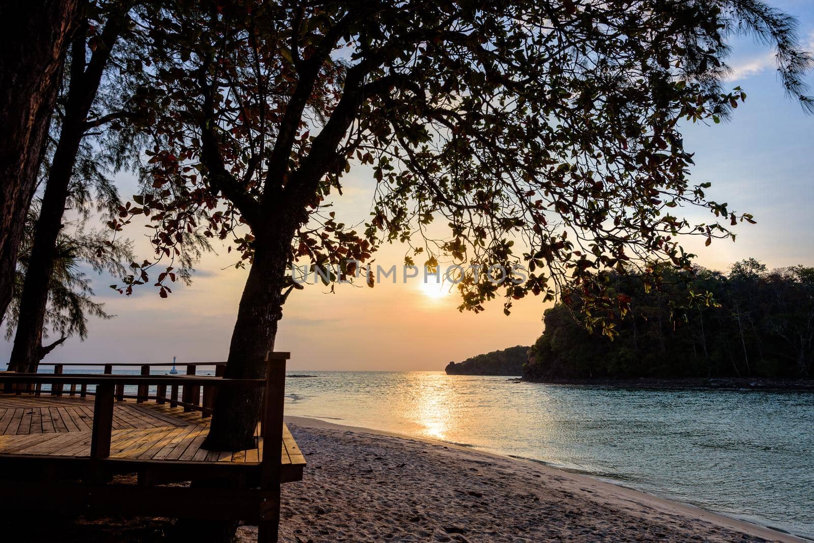 Beautiful nature landscape of colorful the sun on the sky at Tarutao island beach during the sunset over the Andaman Sea under the tree shadow, Tarutao National Park, Satun, Thailand