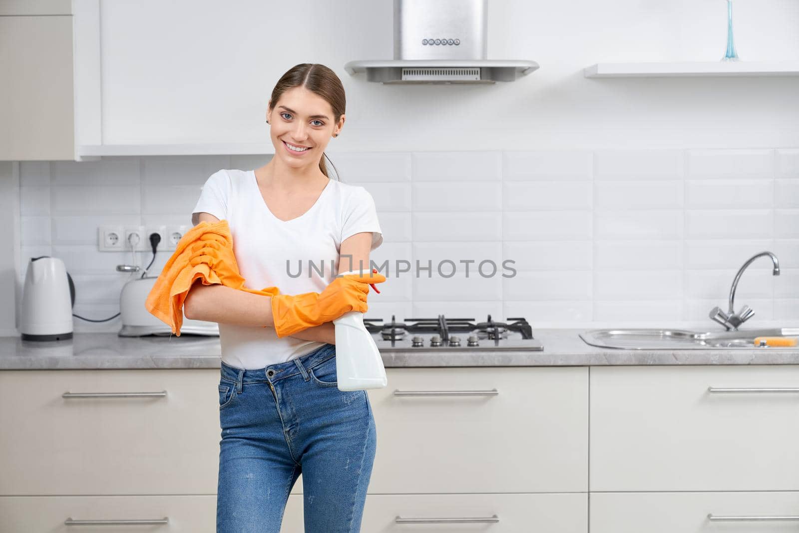 Young smiling cute woman cleaning kitchen. by SerhiiBobyk