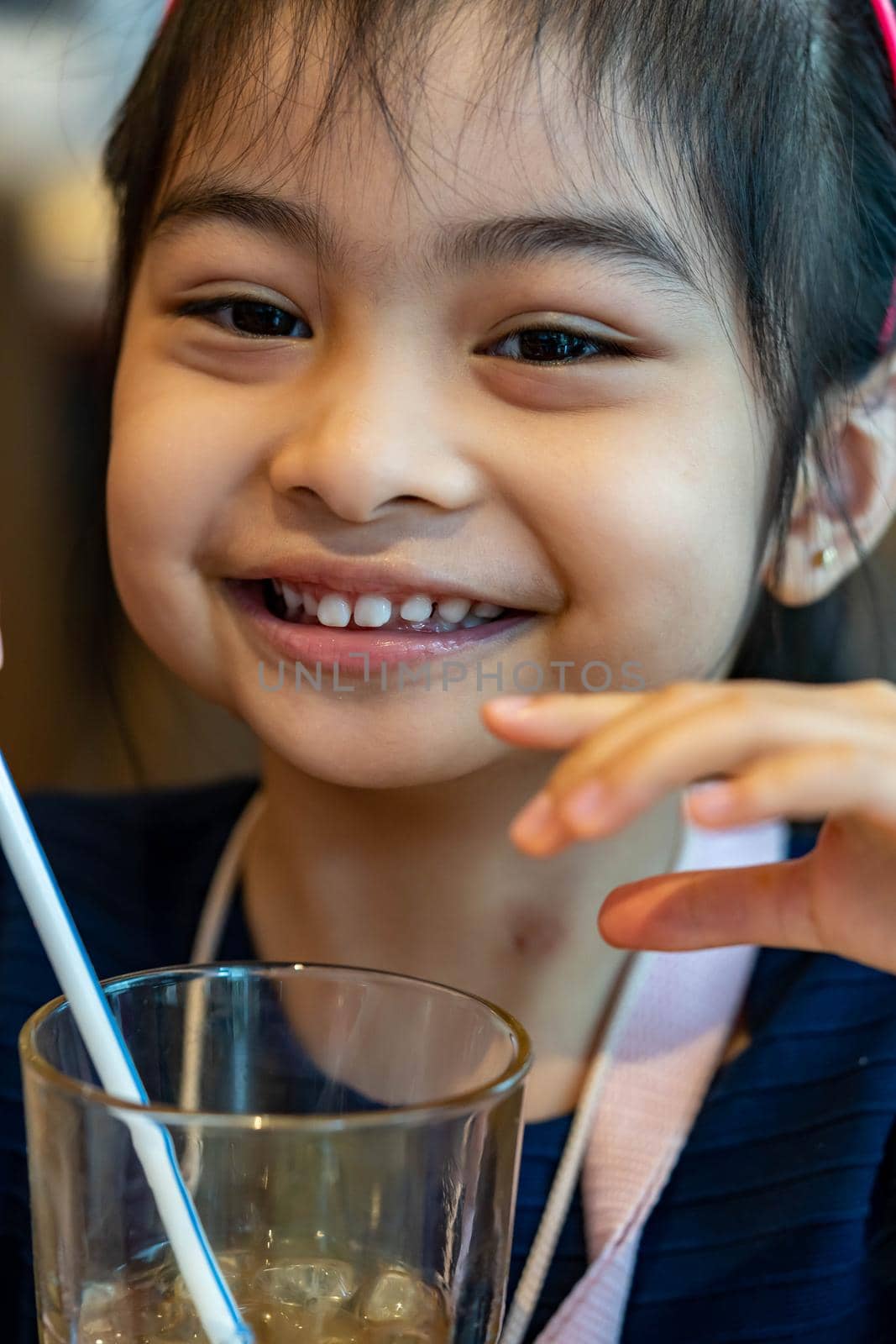 Asian child cute or kid girl drinking water or soy milk beverage in bottle by tube or straw and eating snack or dessert by billroque