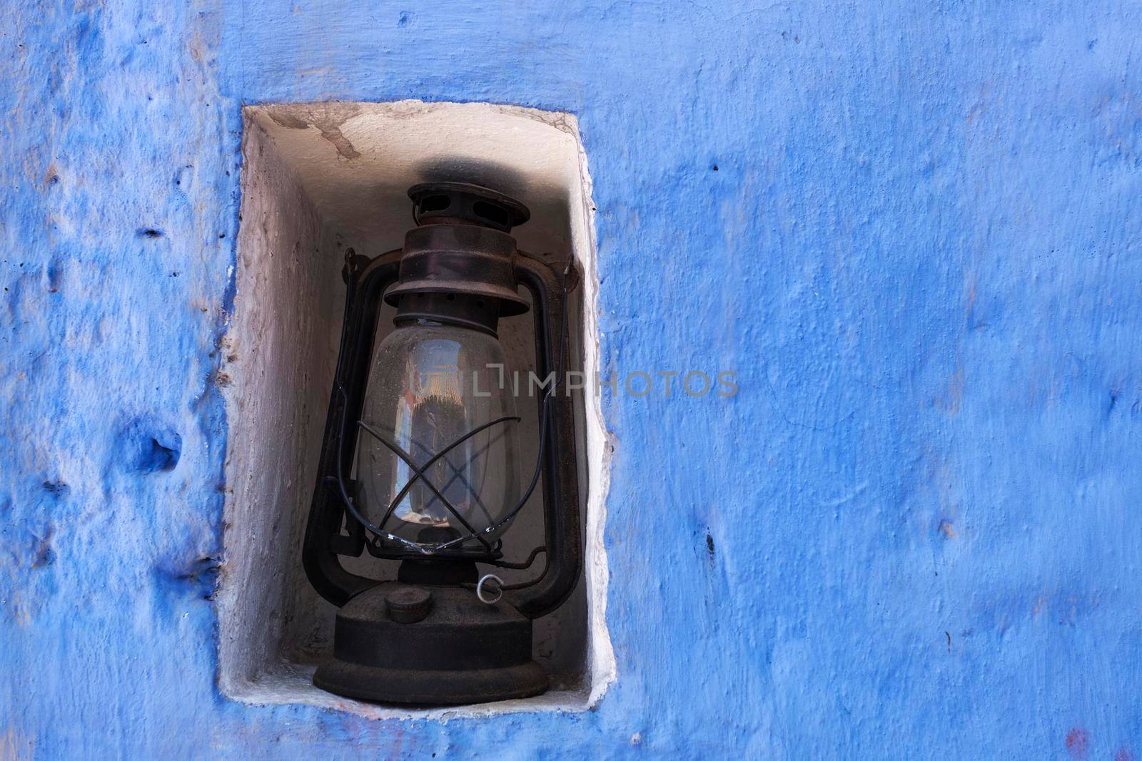 Old lamp and the blue wall. Seen in Arequipa, Peru.