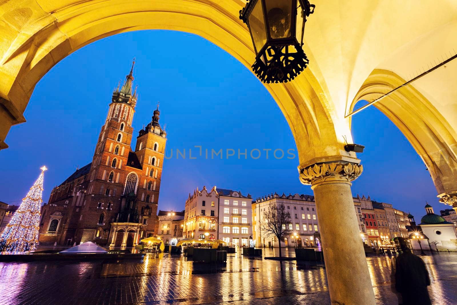 Krakow Main Square at night - seen from the arches of Cloth Hall. Krakow, Lesser Poland, Poland.
