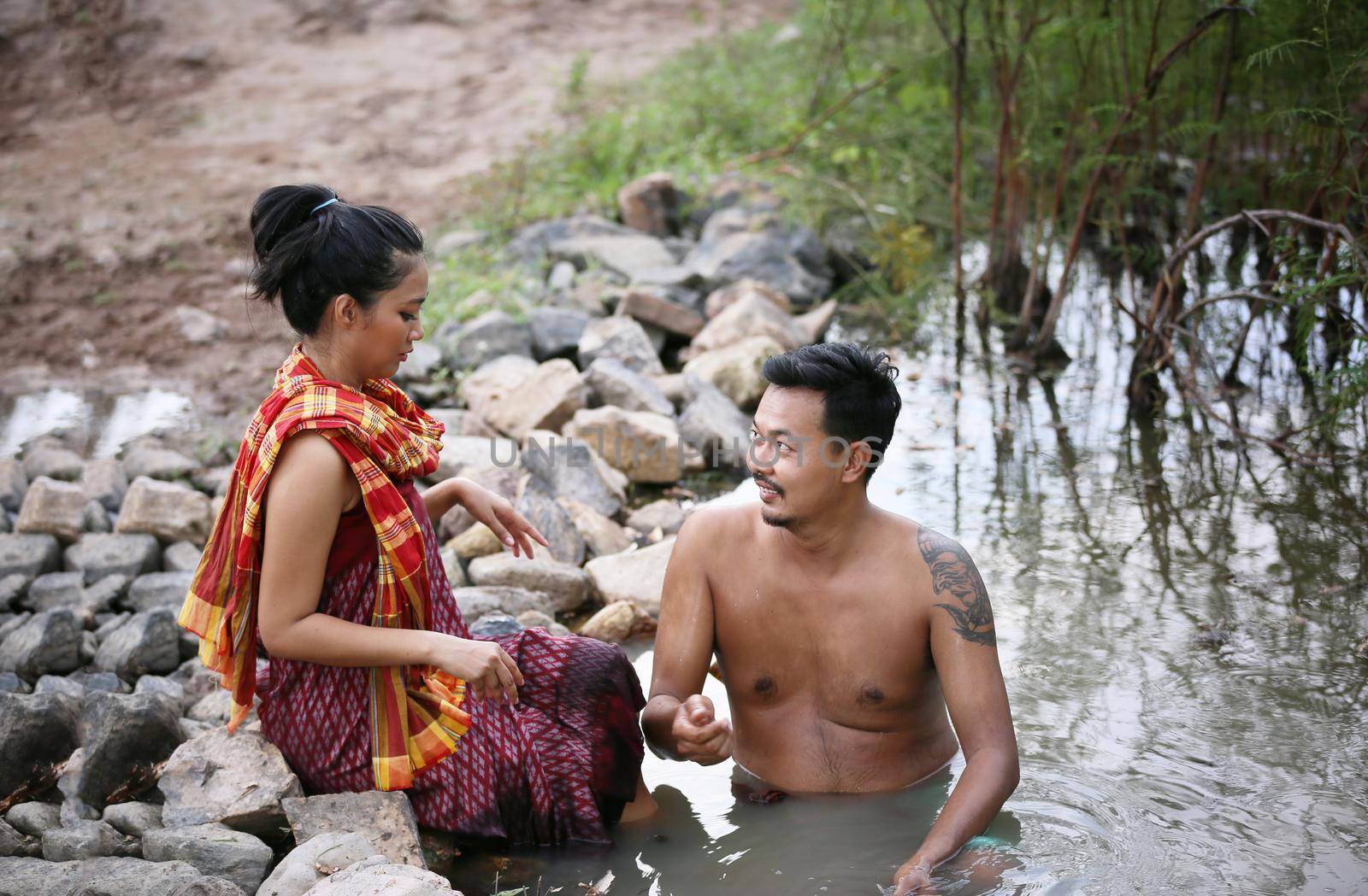 Thailand Couple love enjoy in bathing together in the river against rural background. this is life of young man and young girl couple in Countryside Thai South East Asia.