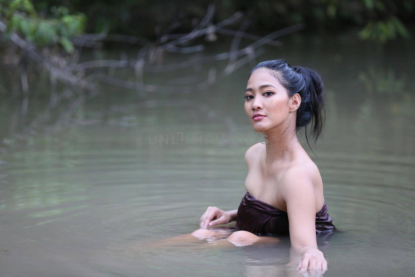 Rural Young Asian Women Bathing In A River, or Portrait Of Beautiful Young Asian Woman Bathing In The River. Asian sexy woman bathing in creek.  by chuanchai
