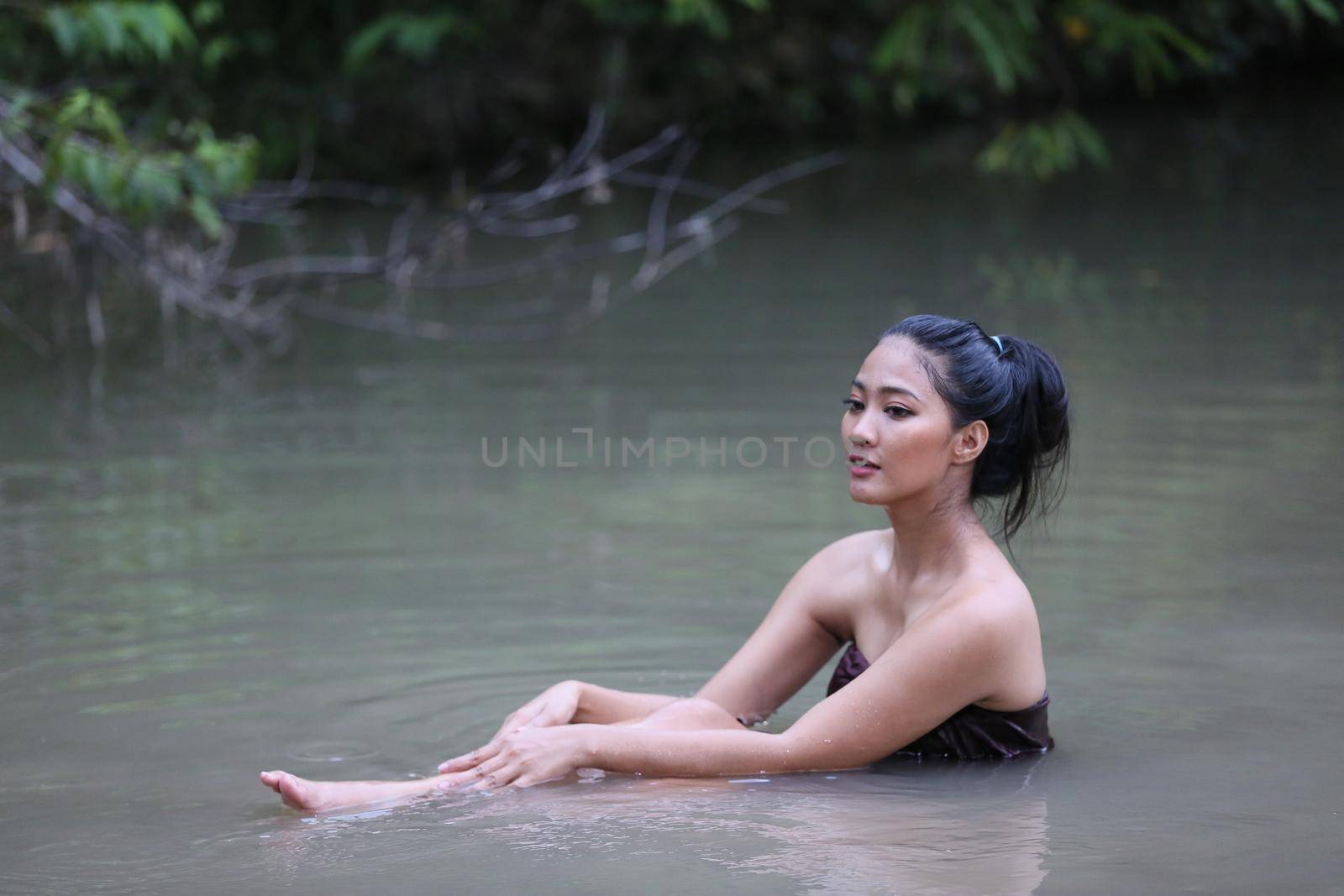 Rural Young Asian Women Bathing In A River, or Portrait Of Beautiful Young Asian Woman Bathing In The River. Asian sexy woman bathing in creek.  by chuanchai