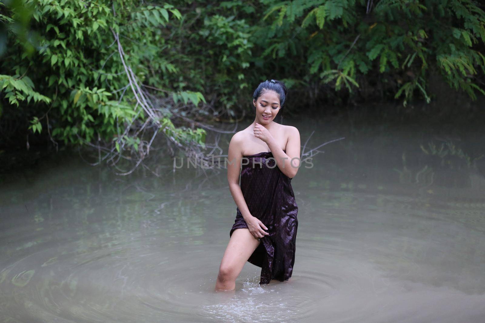 Rural Young Asian Women Bathing In A River, or Portrait Of Beautiful Young Asian Woman Bathing In The River. Asian sexy woman bathing in creek.  by chuanchai