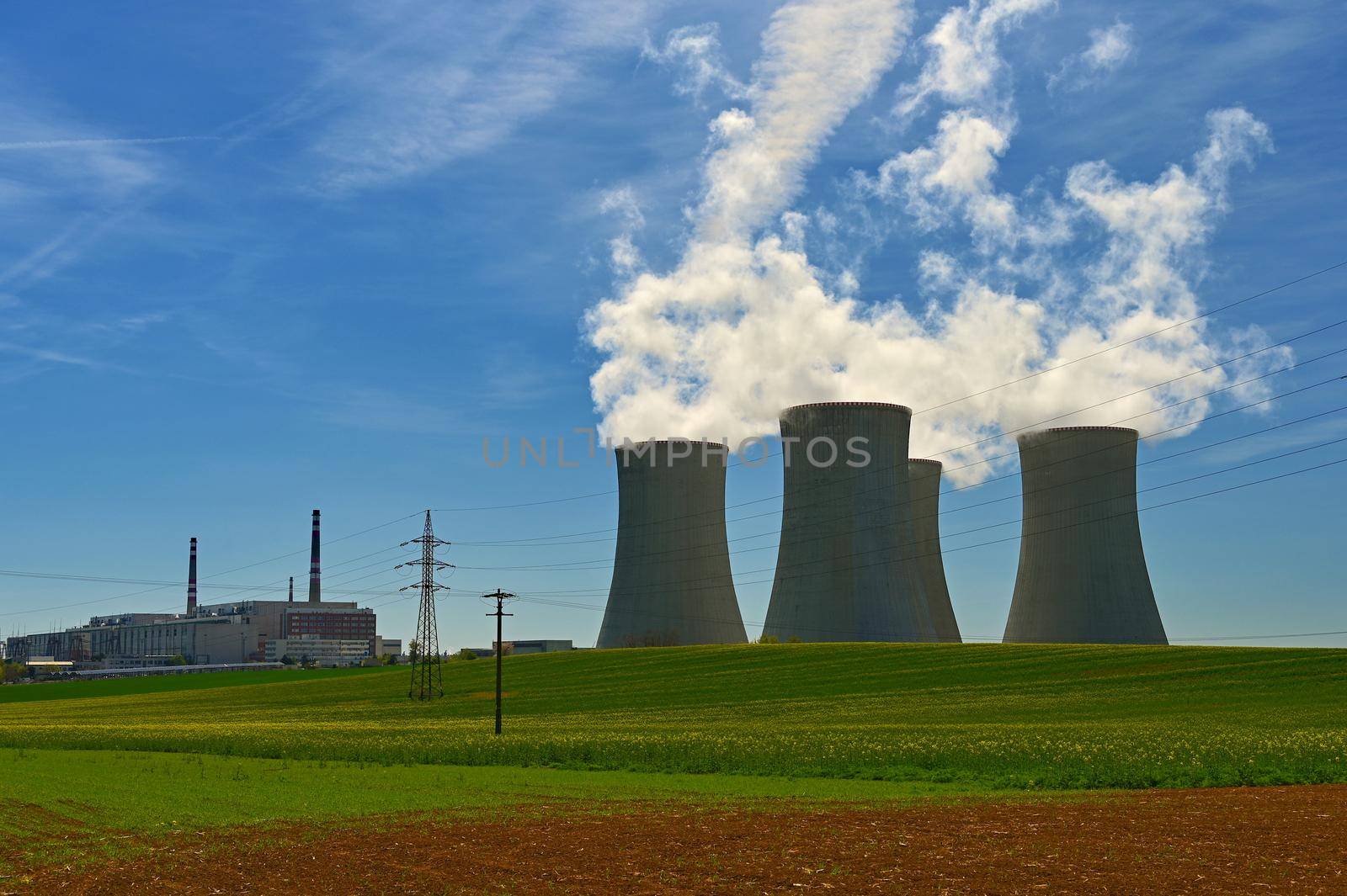 Dukovany Nuclear Power Plant - Czech Republic.
Large chimneys with blue sky and smoke. Concept for industry and environment.