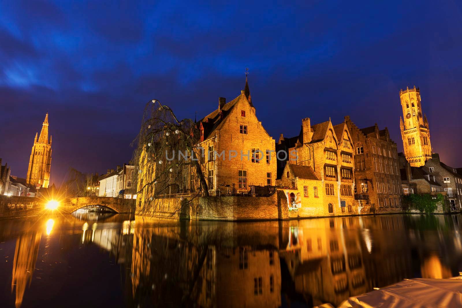 Belfry of Bruges reflected in the canal. Bruges, Flemish Region, Belgium