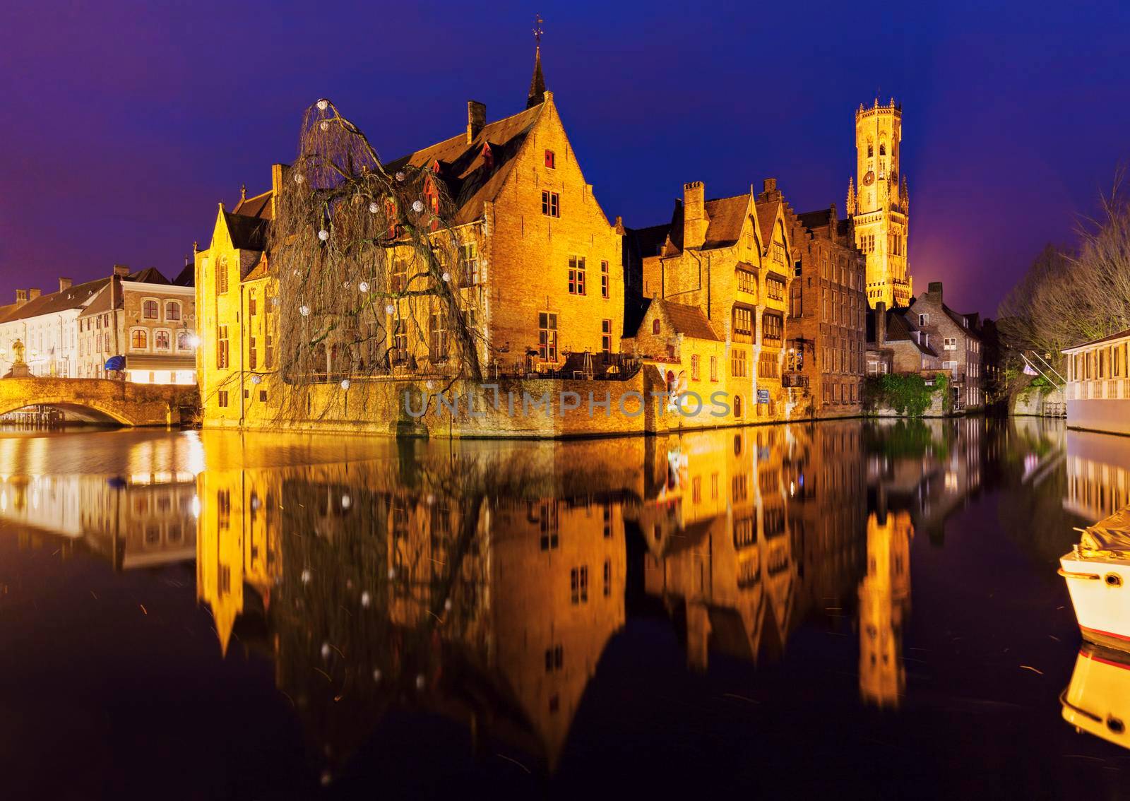 Belfry of Bruges reflected in the canal. Bruges, Flemish Region, Belgium