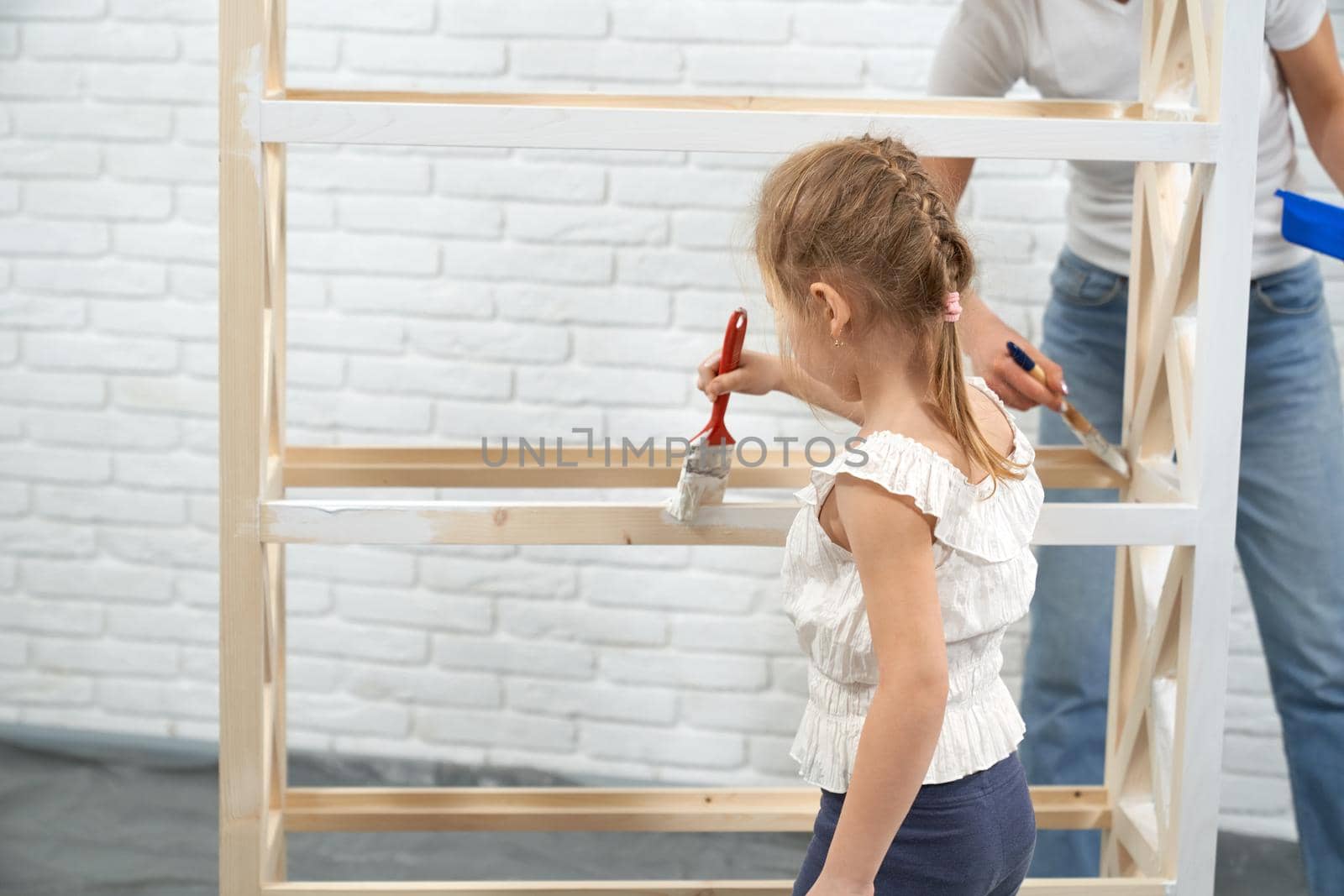 Mother and daughter painting rack at home. by SerhiiBobyk