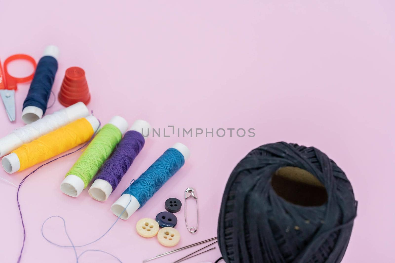 Sewing background. Accessories for needlework on wooden background. Spools of thread, scissors, buttons, measuring tape, sewing supplies. Set for needlework top view