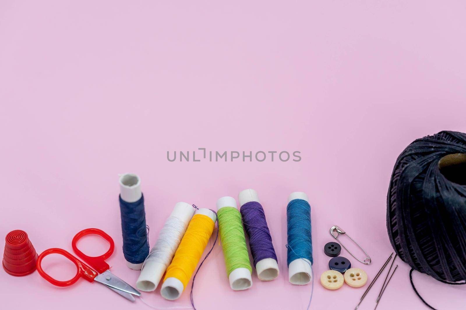 Sewing kit accessories.set tools for tailoring and colorful threads,needles,pins,scissors on green background mockup frame top view.