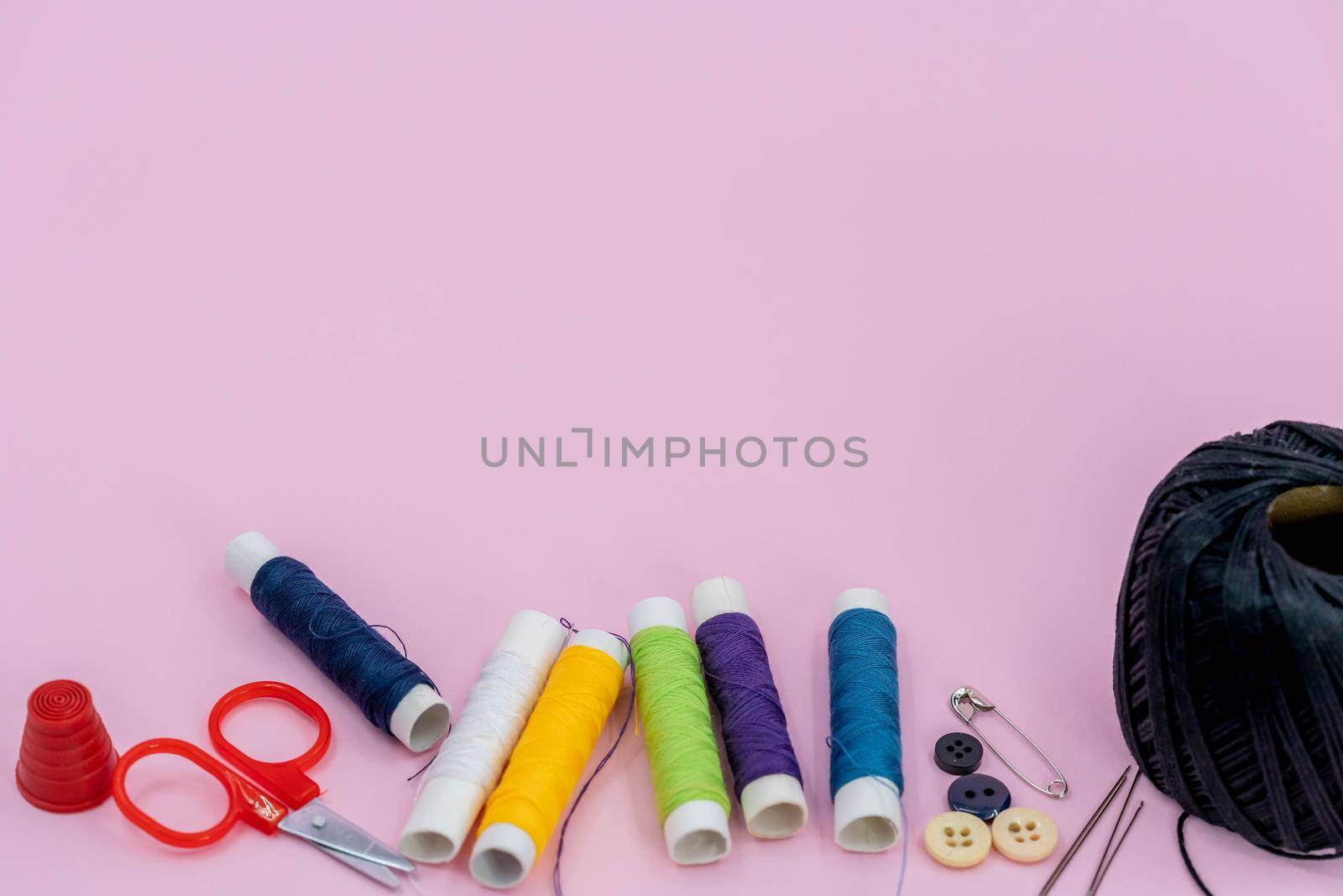 Sewing kit accessories.set tools for tailoring and colorful threads,needles,pins,scissors on green background mockup frame top view.