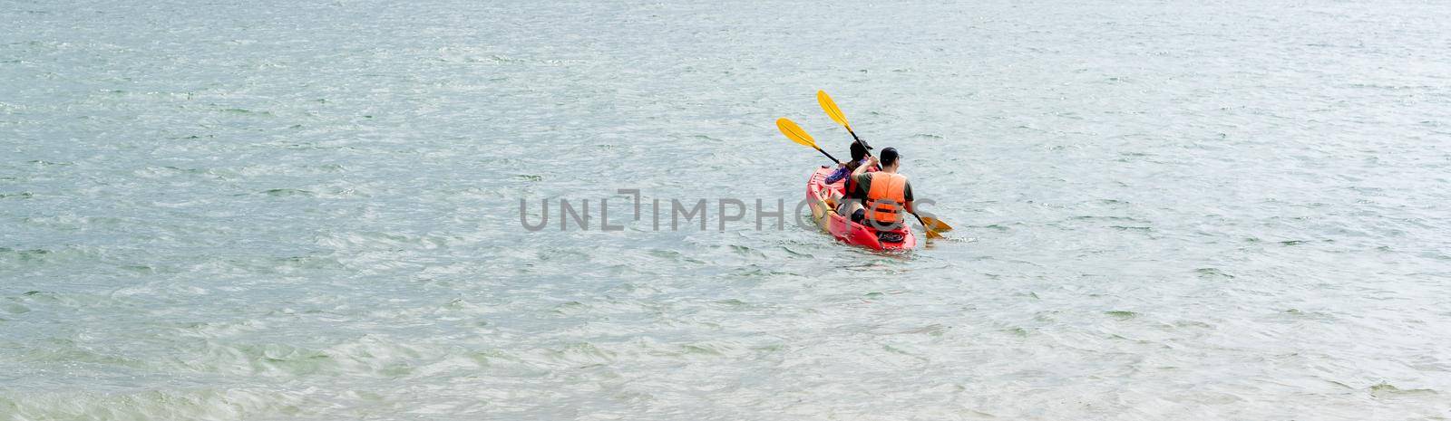 Green blue sea waters with some kayaker men during day. Ocean waters with water sports like kayaking