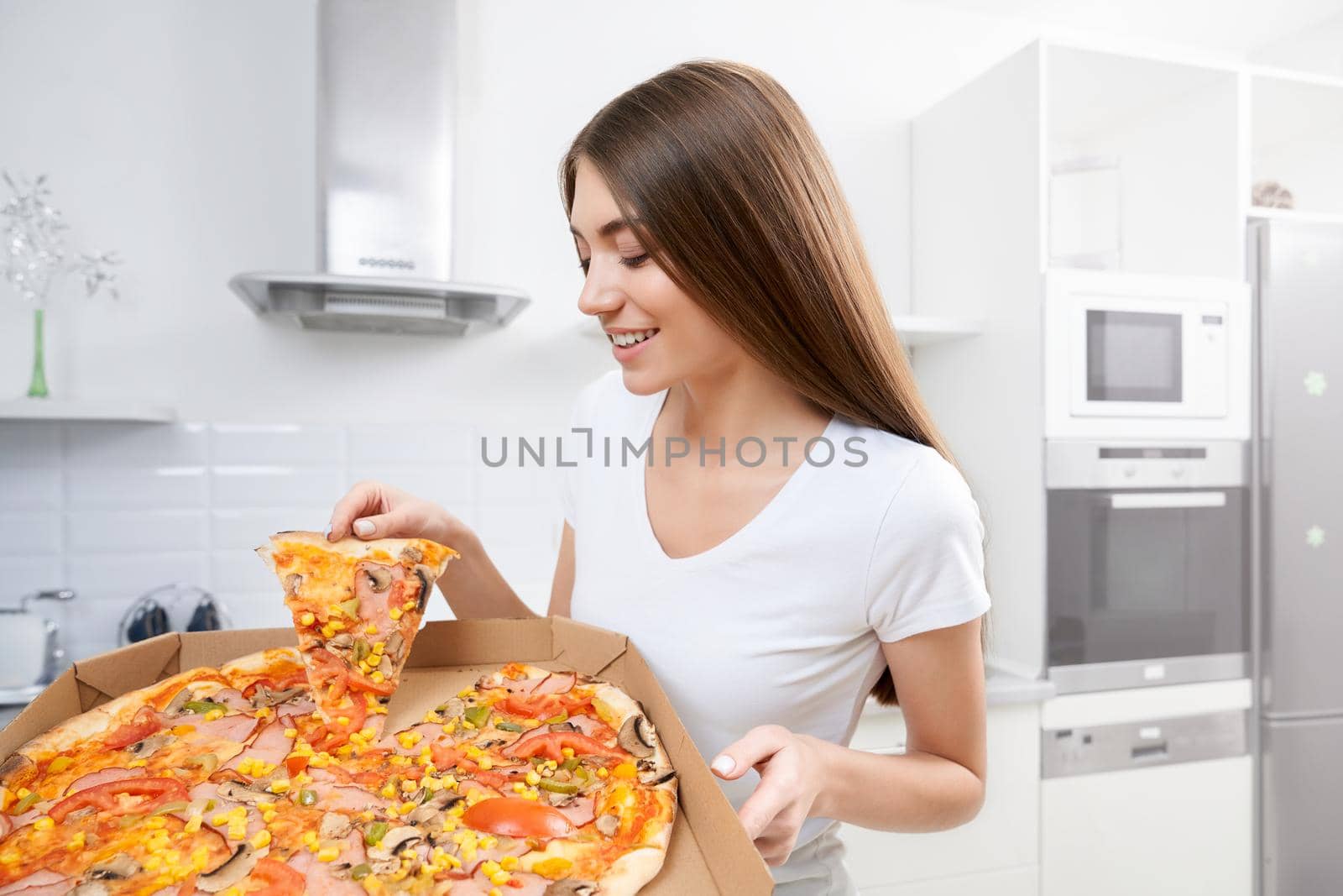 Young woman holding big pizza at home. by SerhiiBobyk
